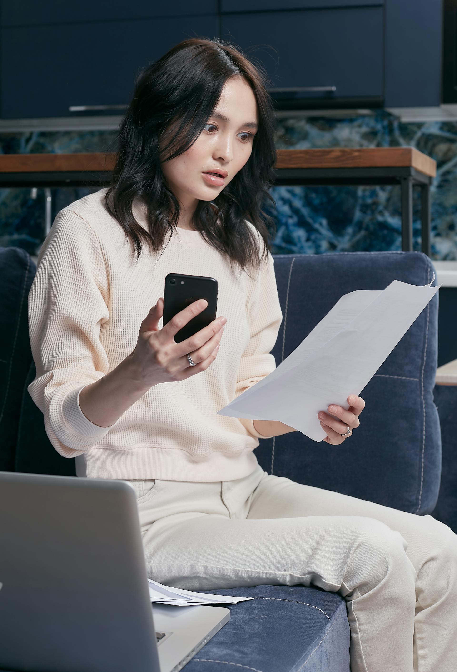 Una mujer conmocionada mirando unos documentos | Fuente: Pexels