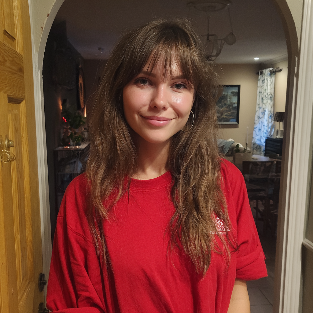 Una mujer sonriente con una camiseta roja | Fuente: Midjourney