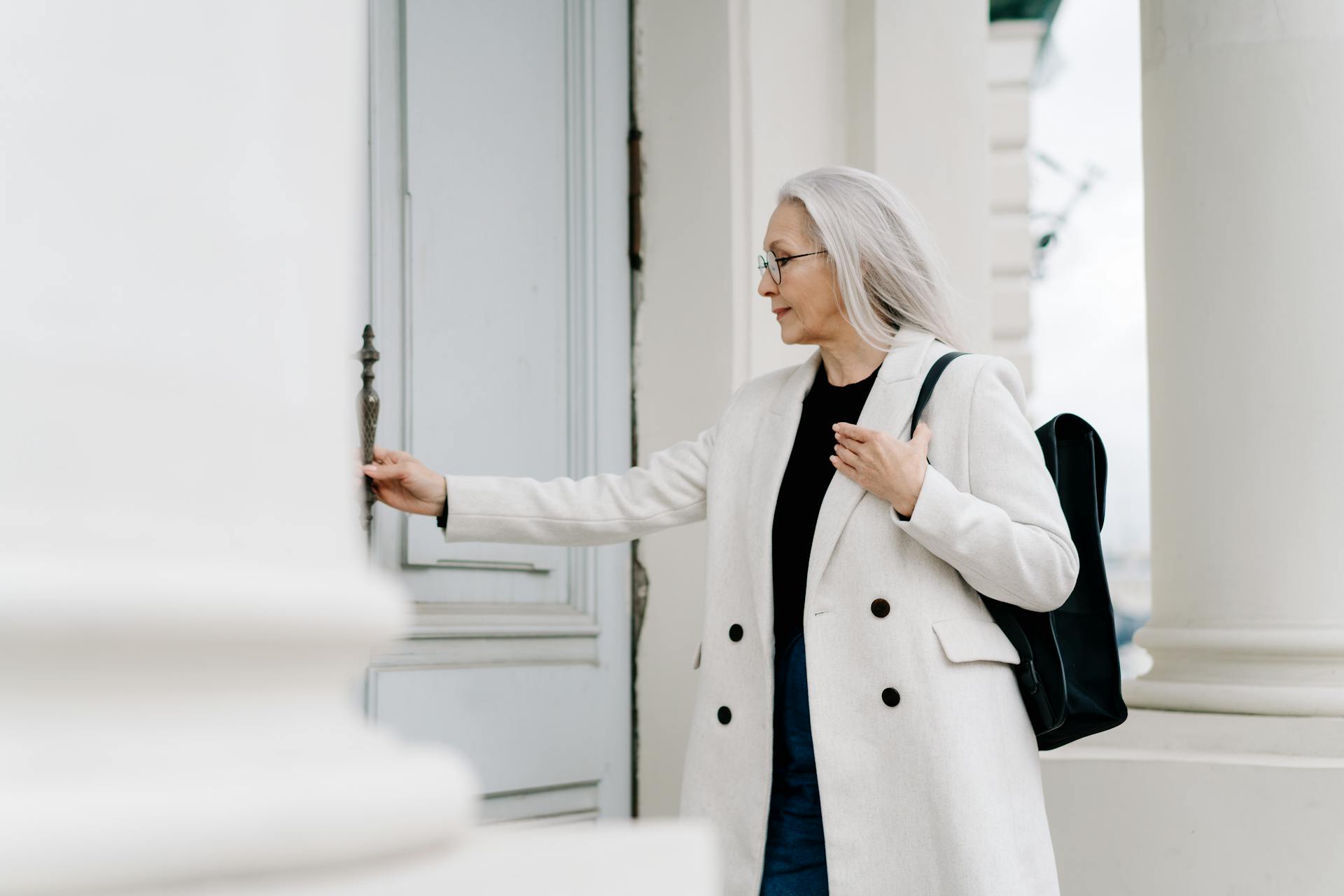 Mujer mayor sujetando la manilla de una puerta | Fuente: Pexels