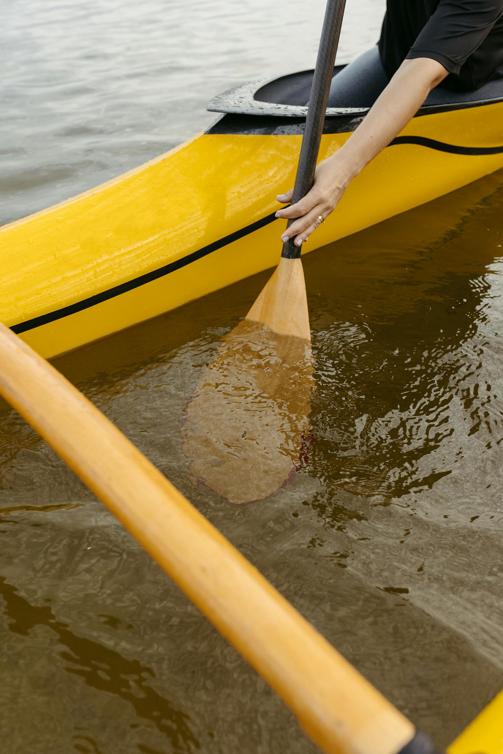 Primer plano de una persona remando en una canoa amarilla | Fuente: Pexels