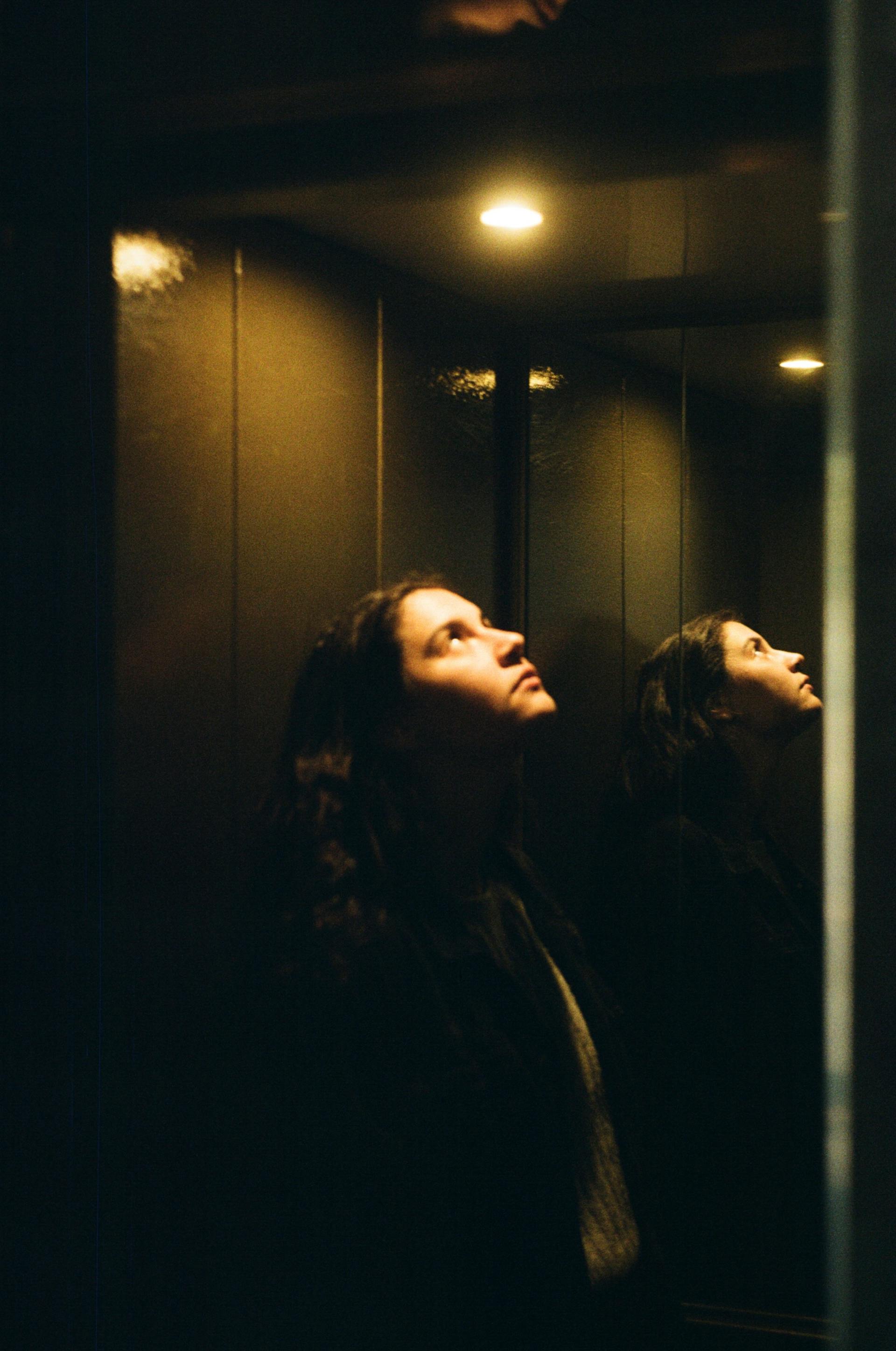 Una mujer en un ascensor mirando la luz | Fuente: Pexels