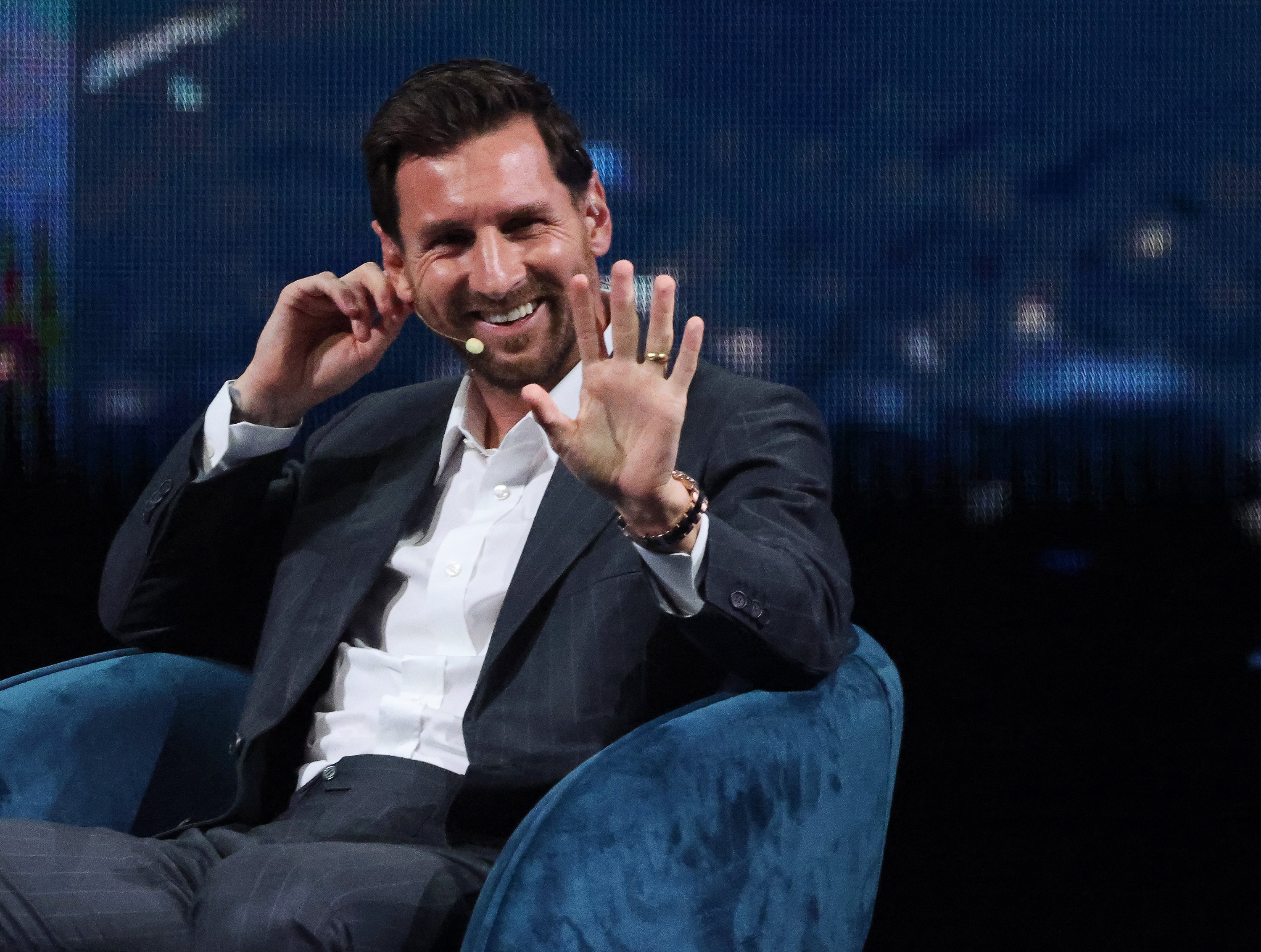 El campeón mundial de fútbol Lionel Messi saluda a sus fans entre los asistentes mientras toma asiento para conversar en español con el alcalde Francis Suárez durante el Foro Empresarial Americano en el Centro Kaseya de Miami, el miércoles 5 de noviembre de 2025. | Fuente: Getty Images.