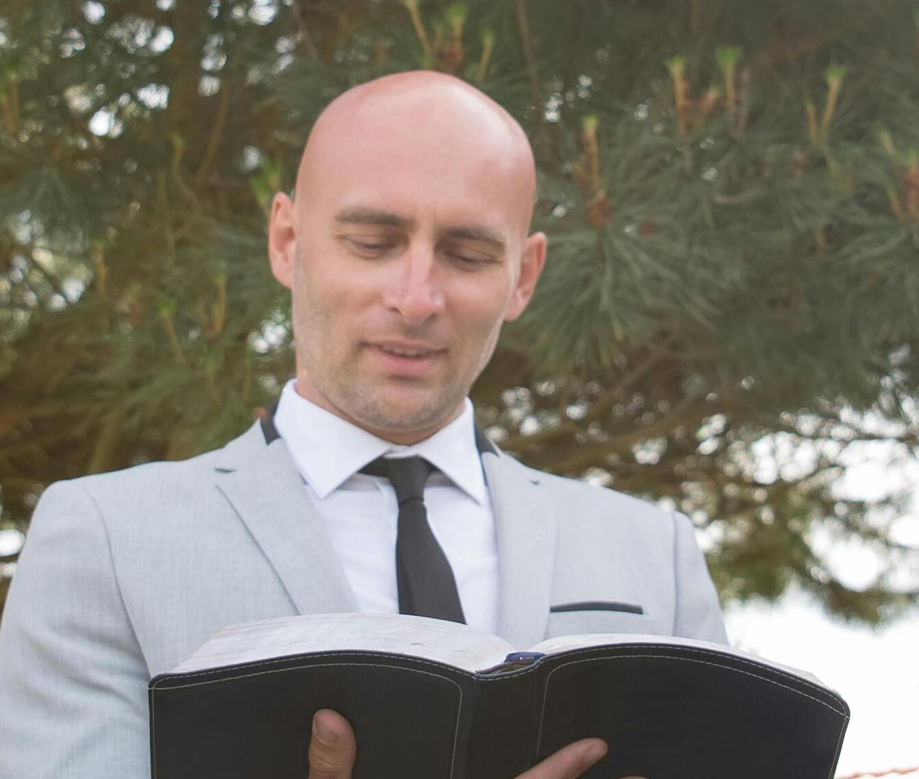 Un hombre, actuando como oficiante de una boda, leyendo un libro | Fuente: Pexels