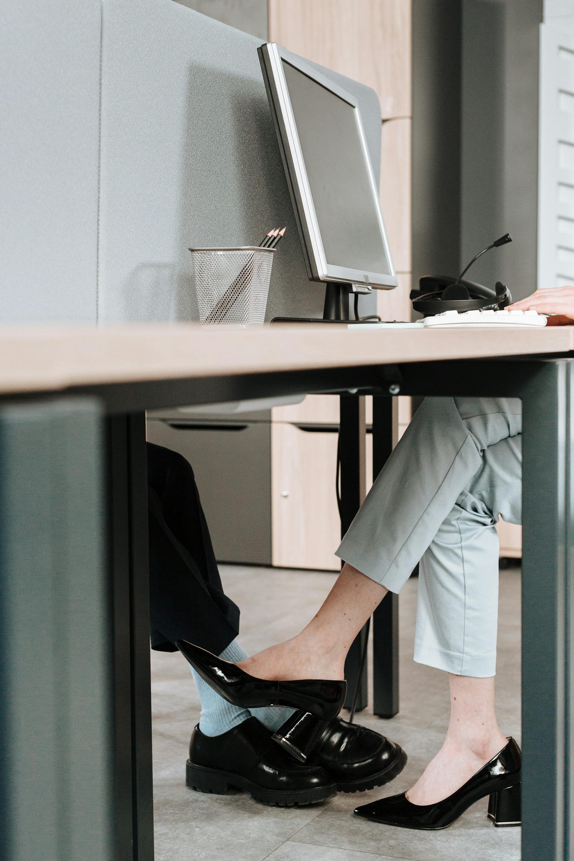 Colegas flirteando bajo la mesa | Fuente: Pexels