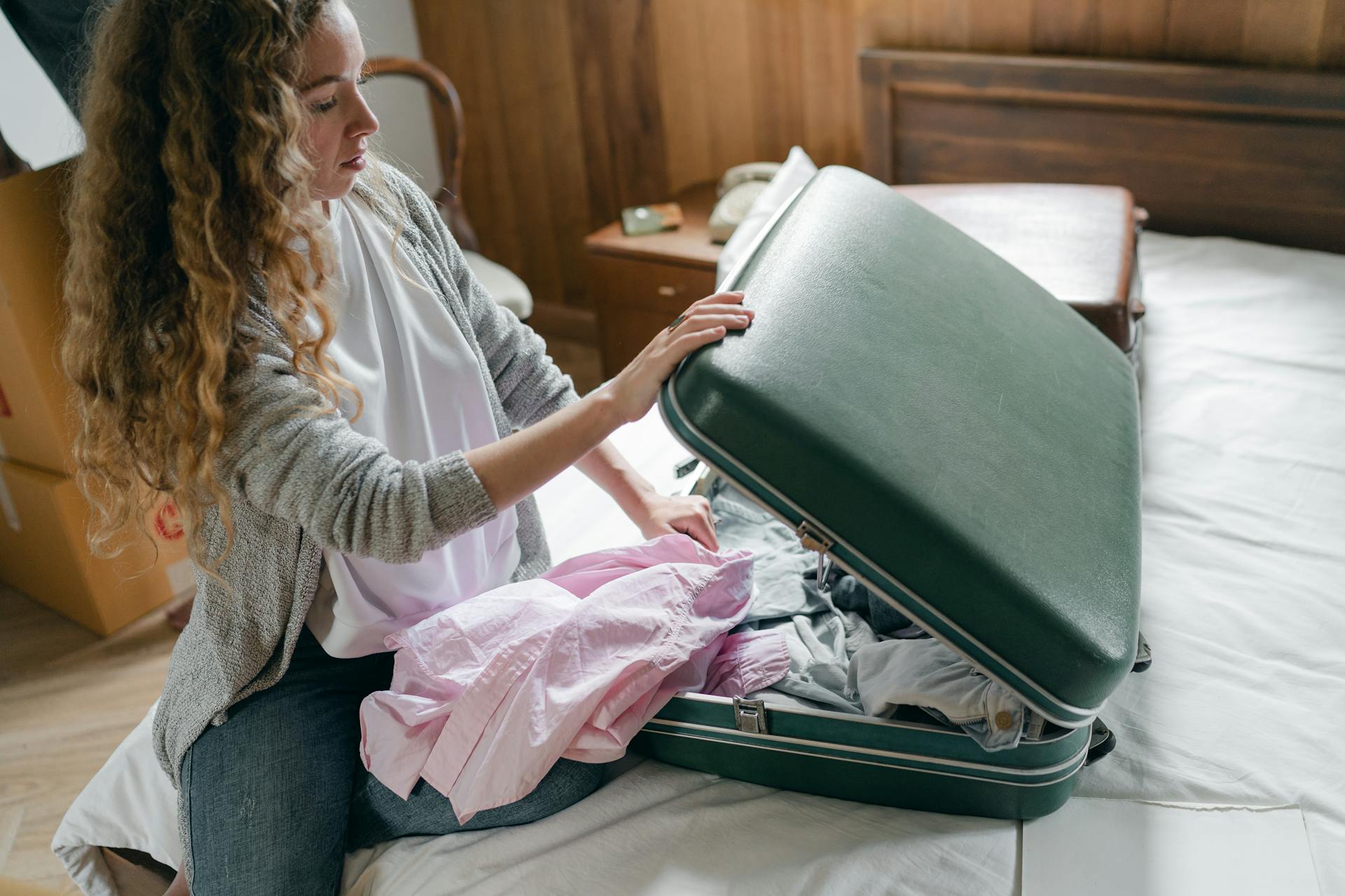 Una mujer metiendo ropa en una maleta | Fuente: Pexels