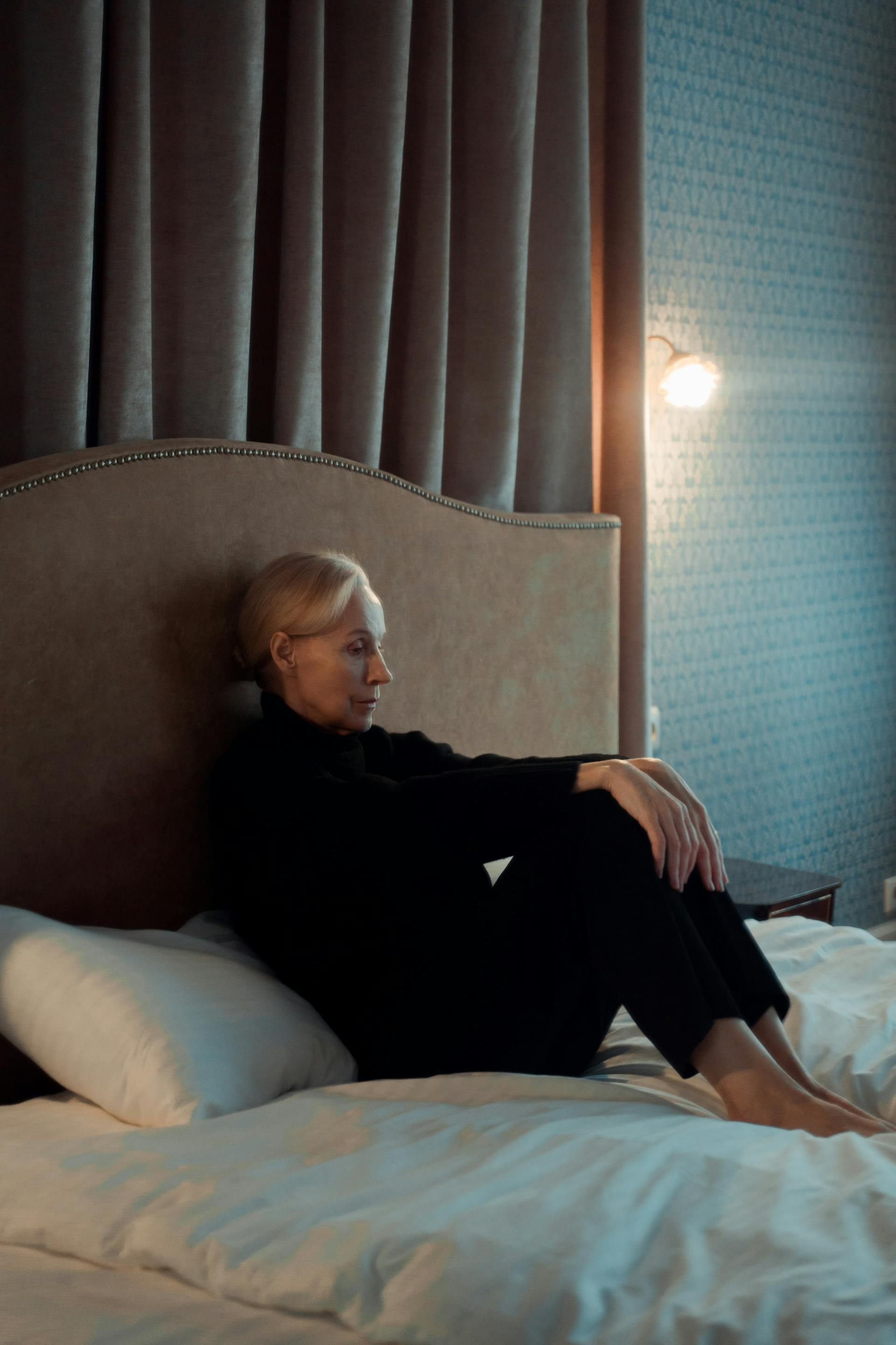 Una mujer sentada en su cama | Fuente: Pexels
