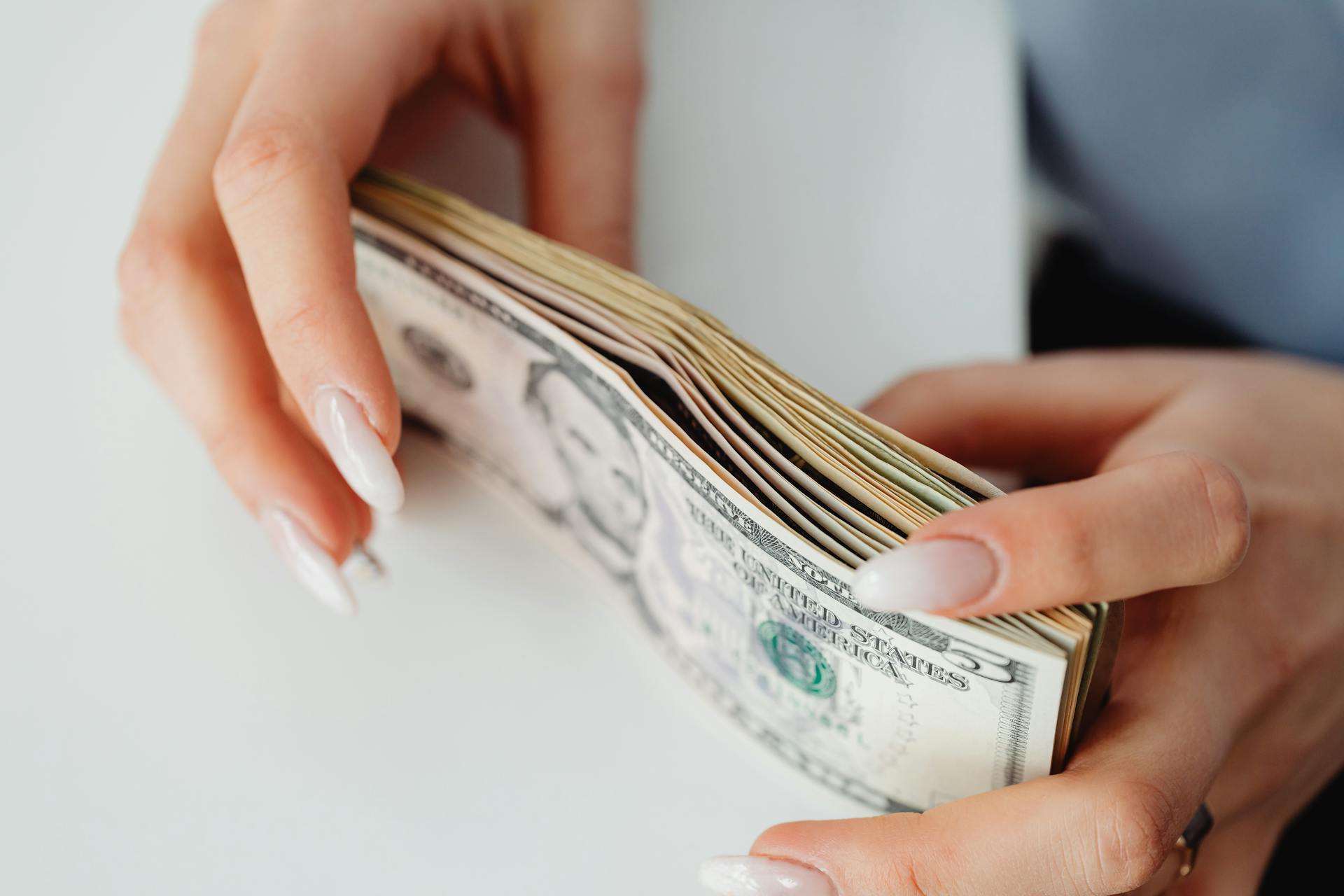 Una mujer con dinero en la mano | Fuente: Pexels