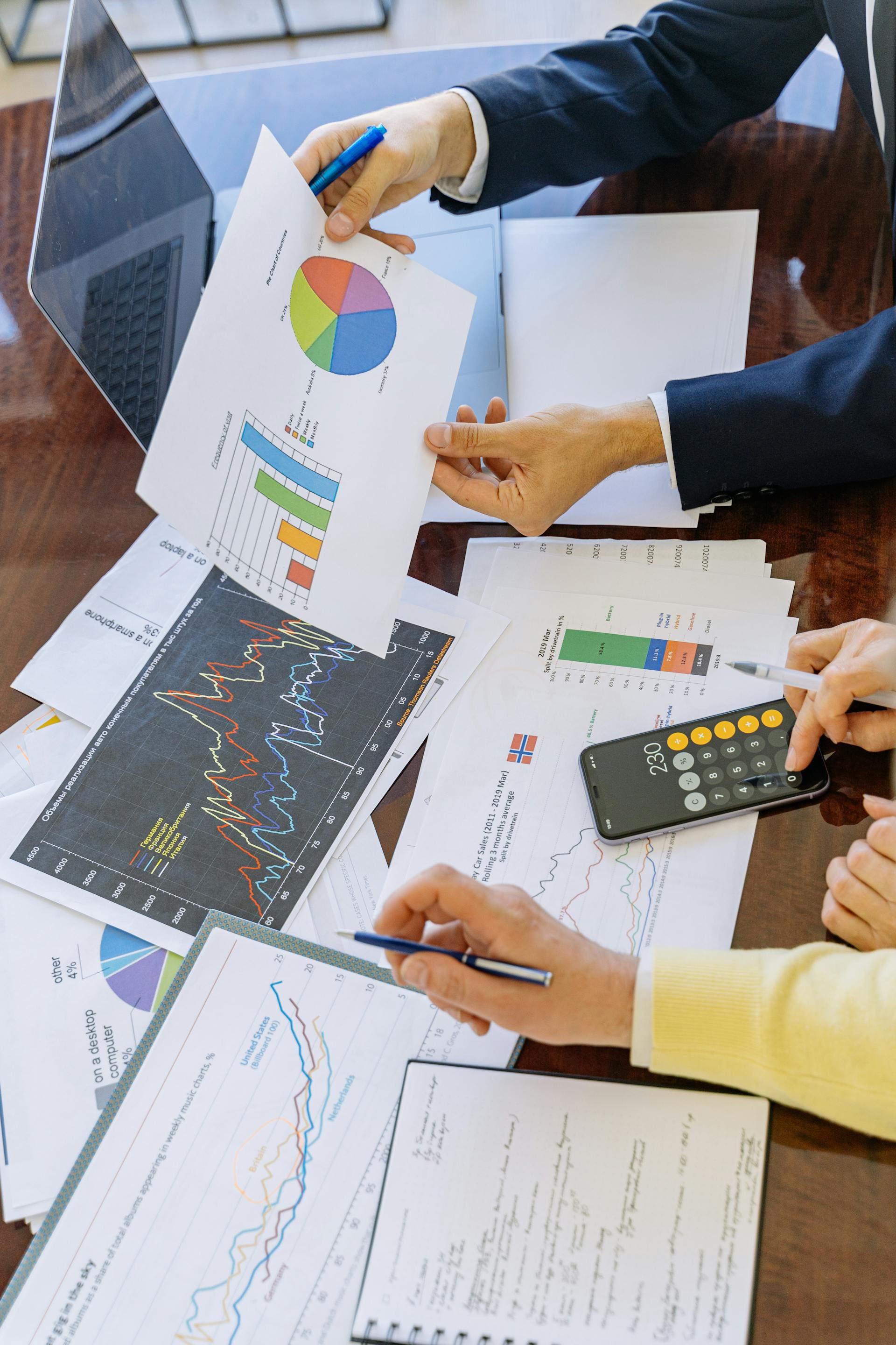 Primer plano de dos personas analizando gráficos y diagramas circulares en una oficina | Fuente: Pexels