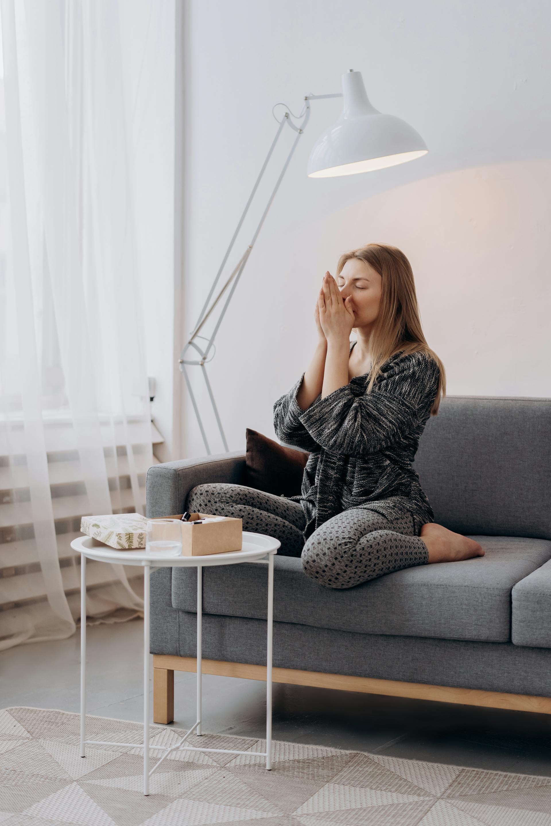 Una mujer cansada sentada en el sofá | Fuente: Pexels