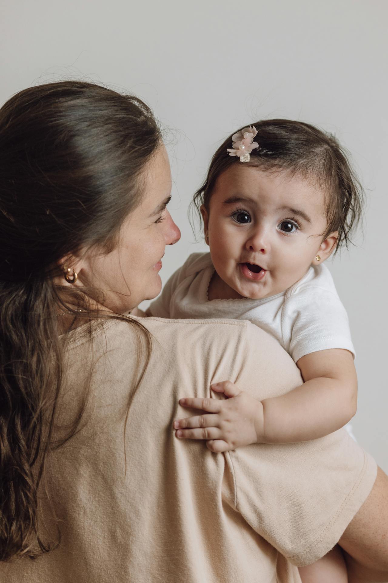 Una madre con su hija en brazos | Fuente: Pexels