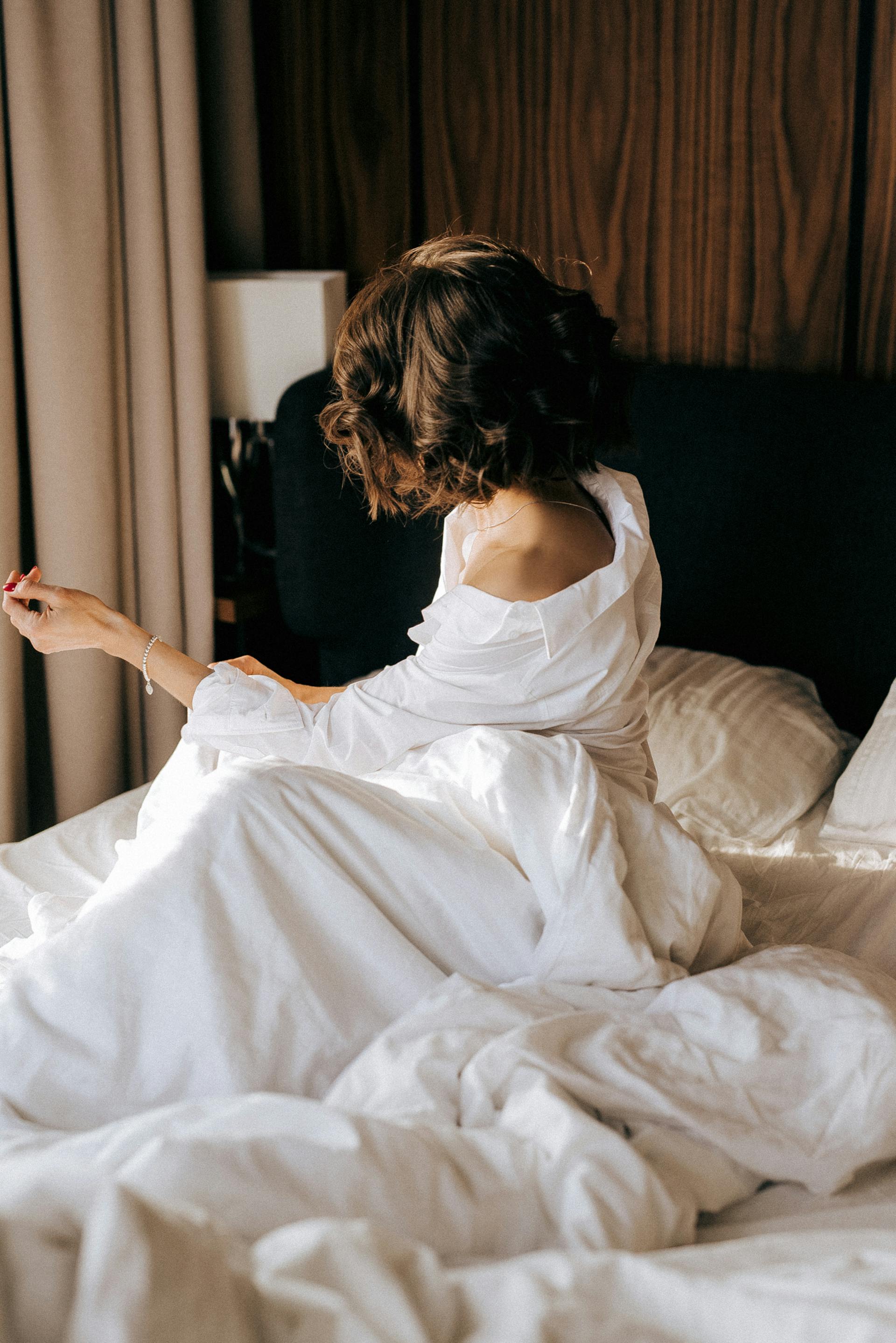 Una mujer sentada en la cama | Fuente: Pexels