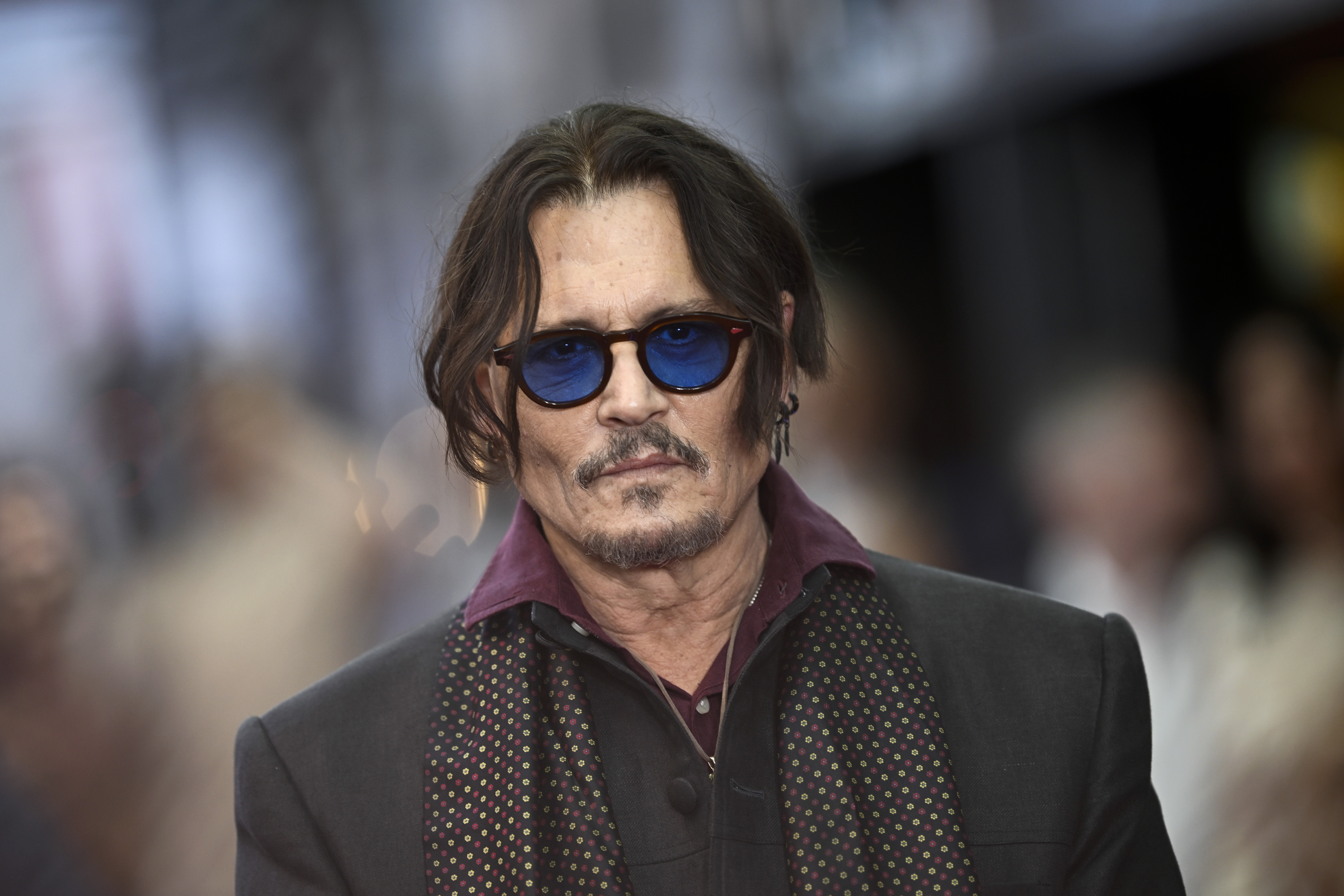 Johnny Depp posa para fotos con gafas de sol con lentes azulados en el estreno en Reino Unido de "Modigliani: Three Days on the Wing of Madness", en Londres, el 8 de julio de 2025 | Fuente: Getty Images