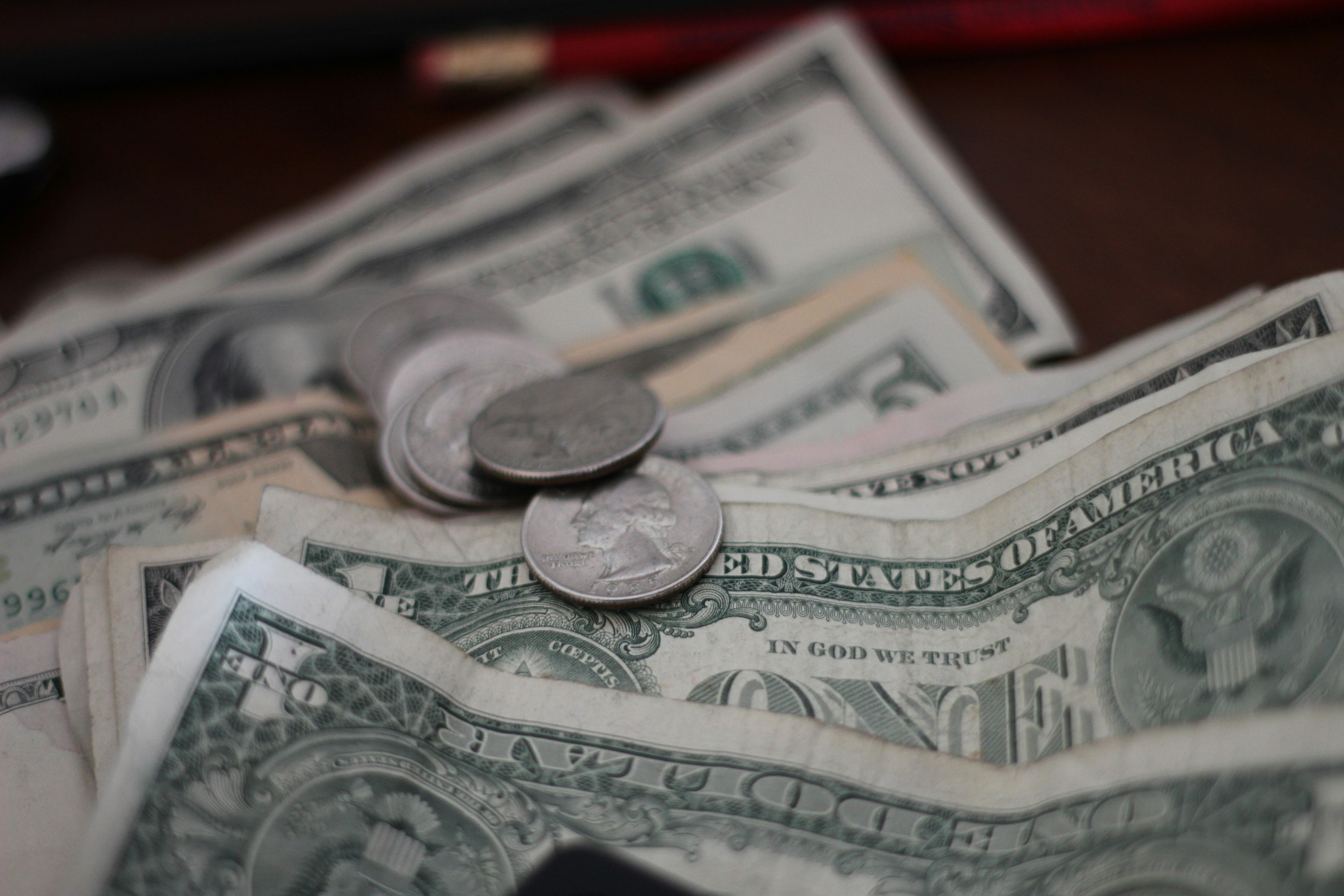 Un primer plano de dólares y monedas | Fuente: Unsplash