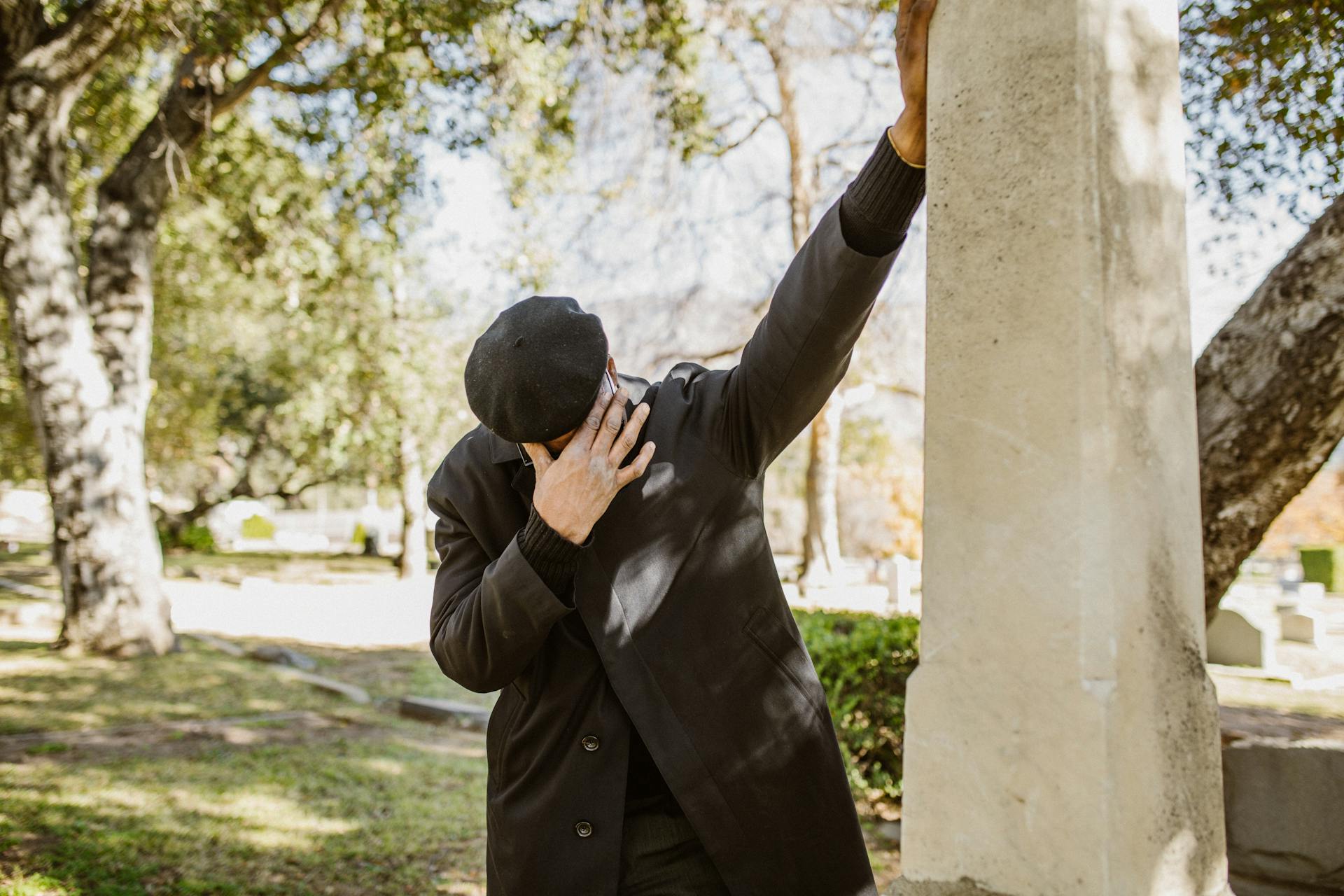 Un hombre afligido junto a una estructura de hormigón gris | Fuente: Pexels