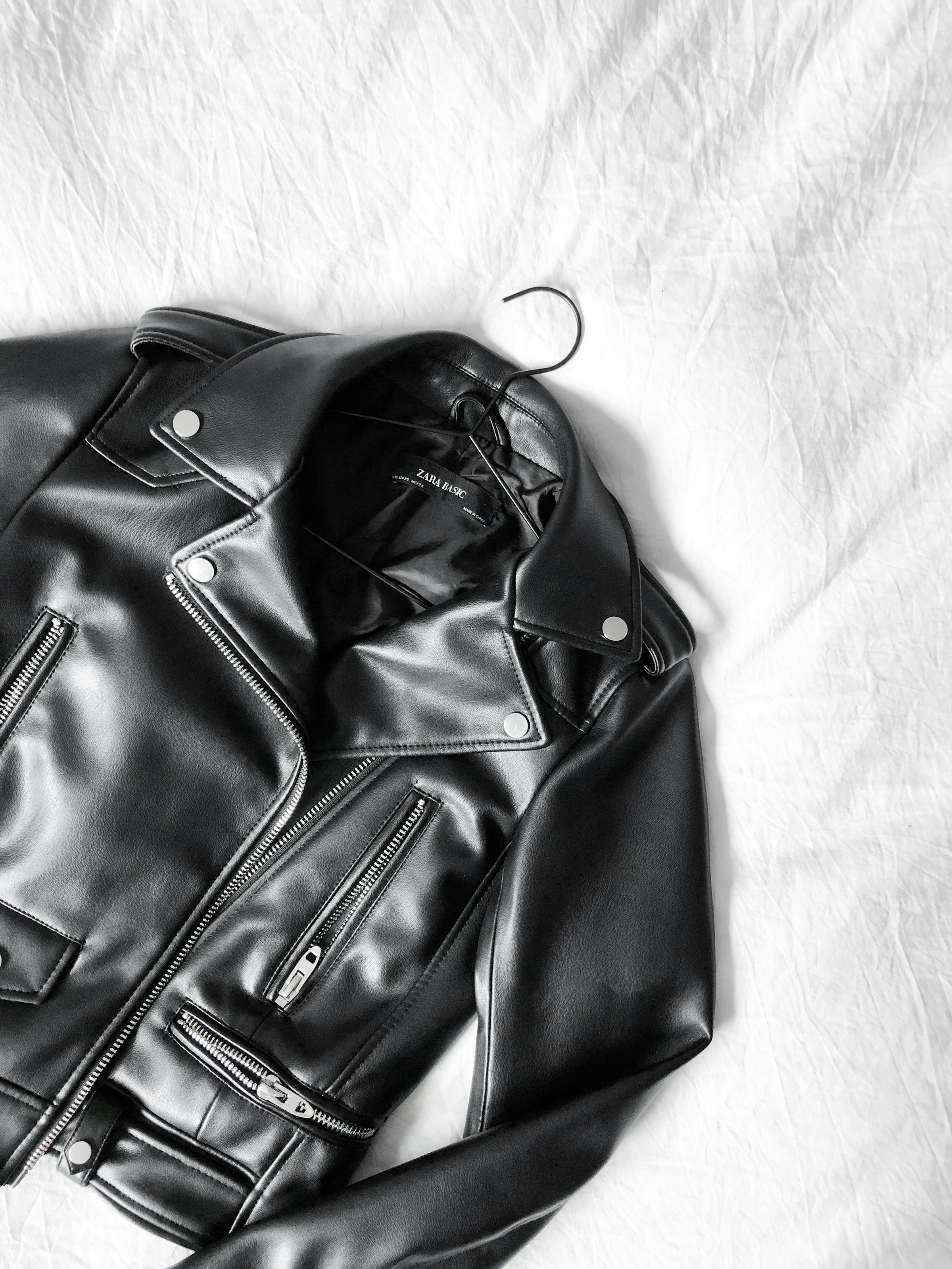 Una chaqueta negra tendida en una cama | Fuente: Unsplash