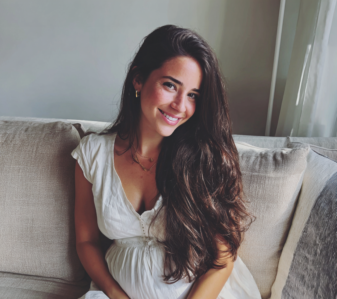 Una mujer embarazada sonriente con un vestido blanco | Fuente: Midjourney