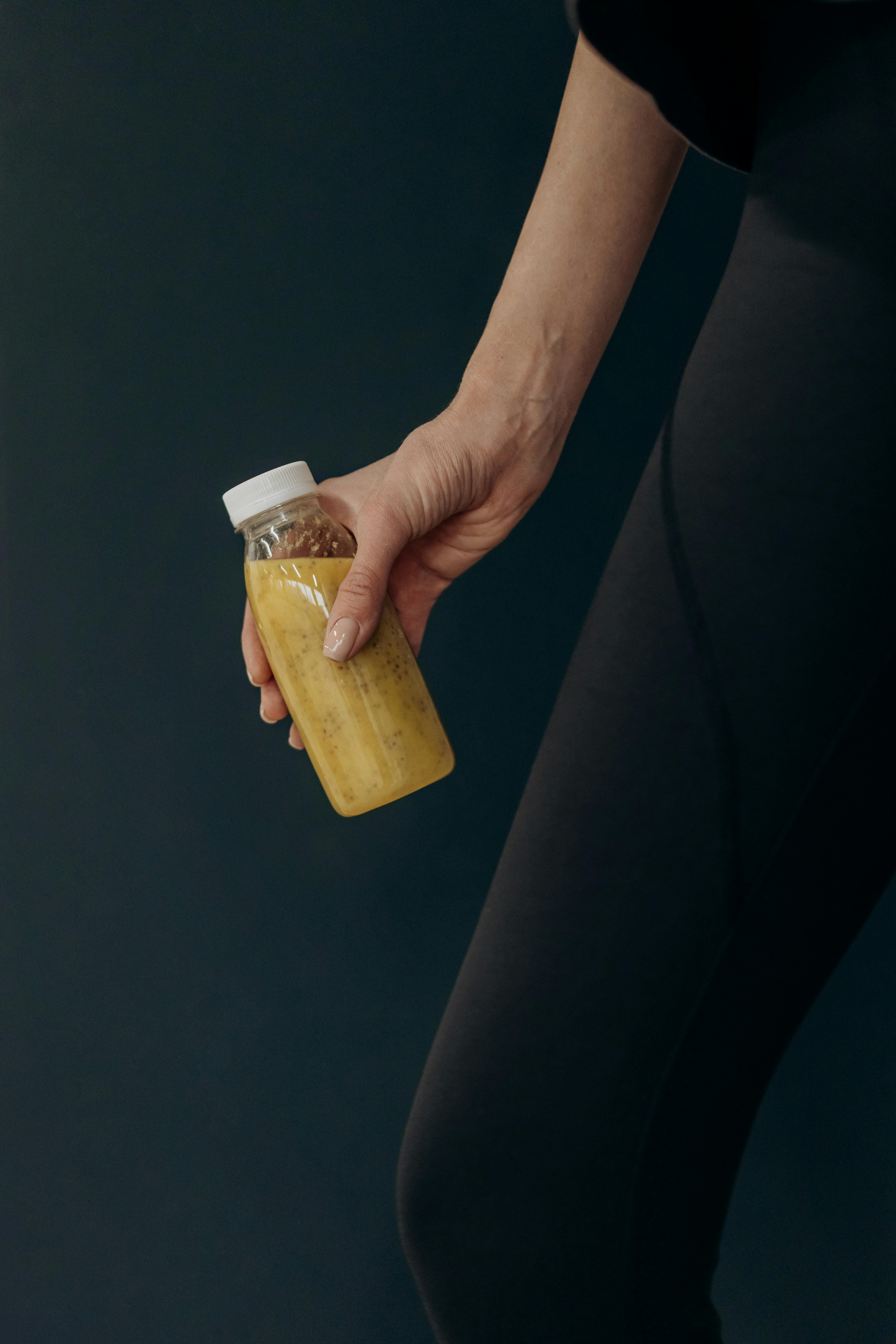Una mujer con un batido en la mano | Fuente: Pexels
