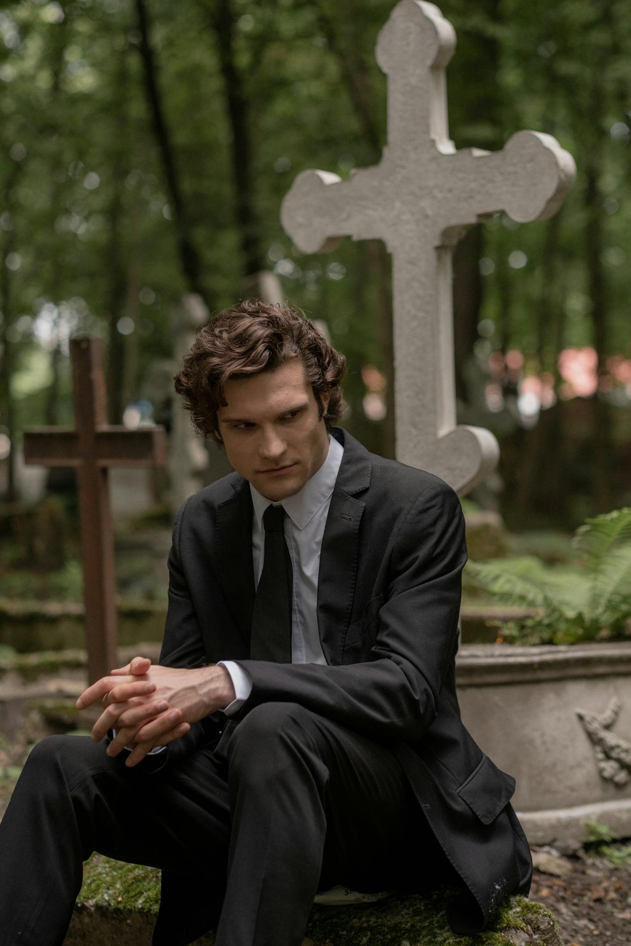 Un hombre sentado en un cementerio | Fuente: Pexels
