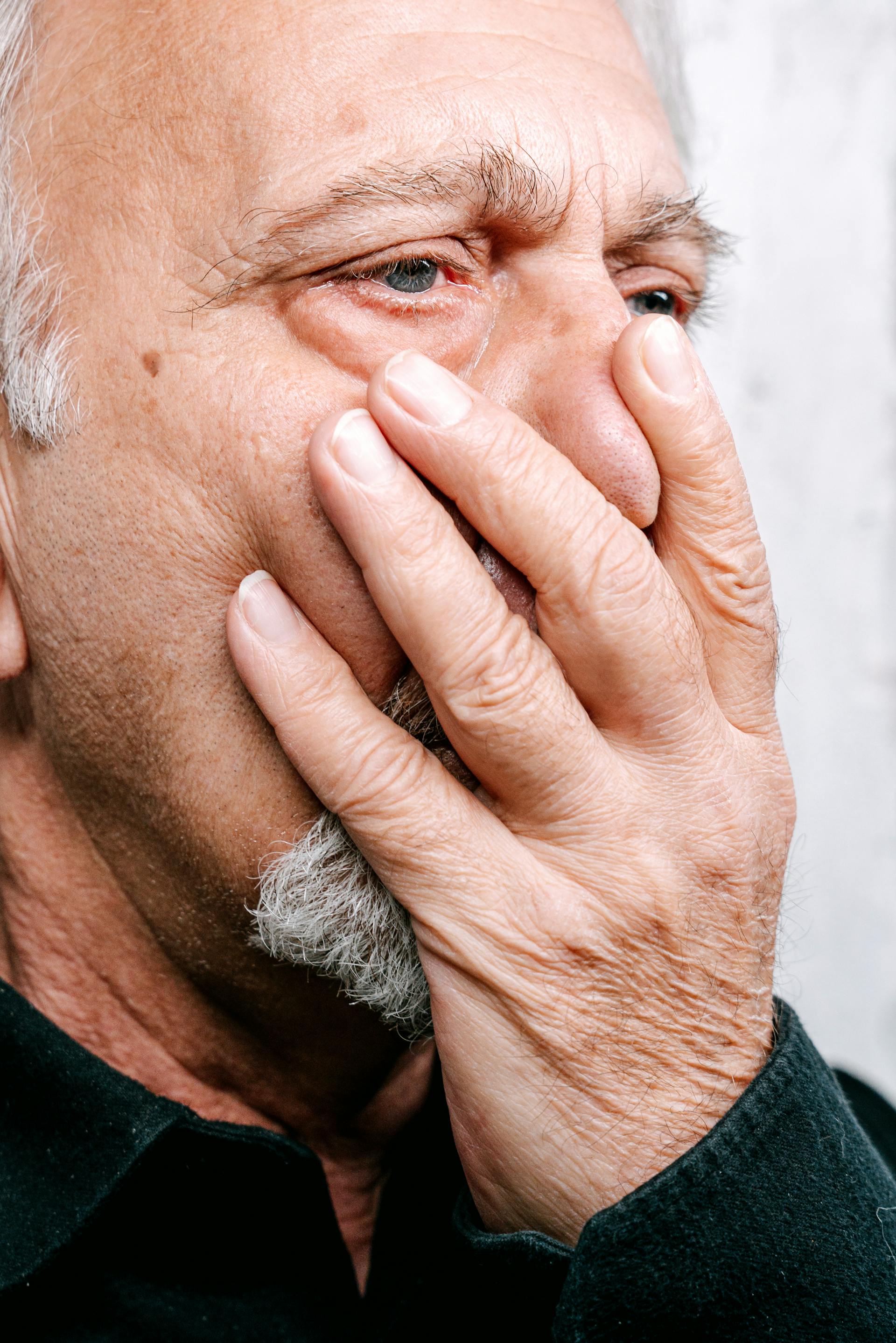 Un hombre tapándose la boca con una mano | Fuente: Pexels
