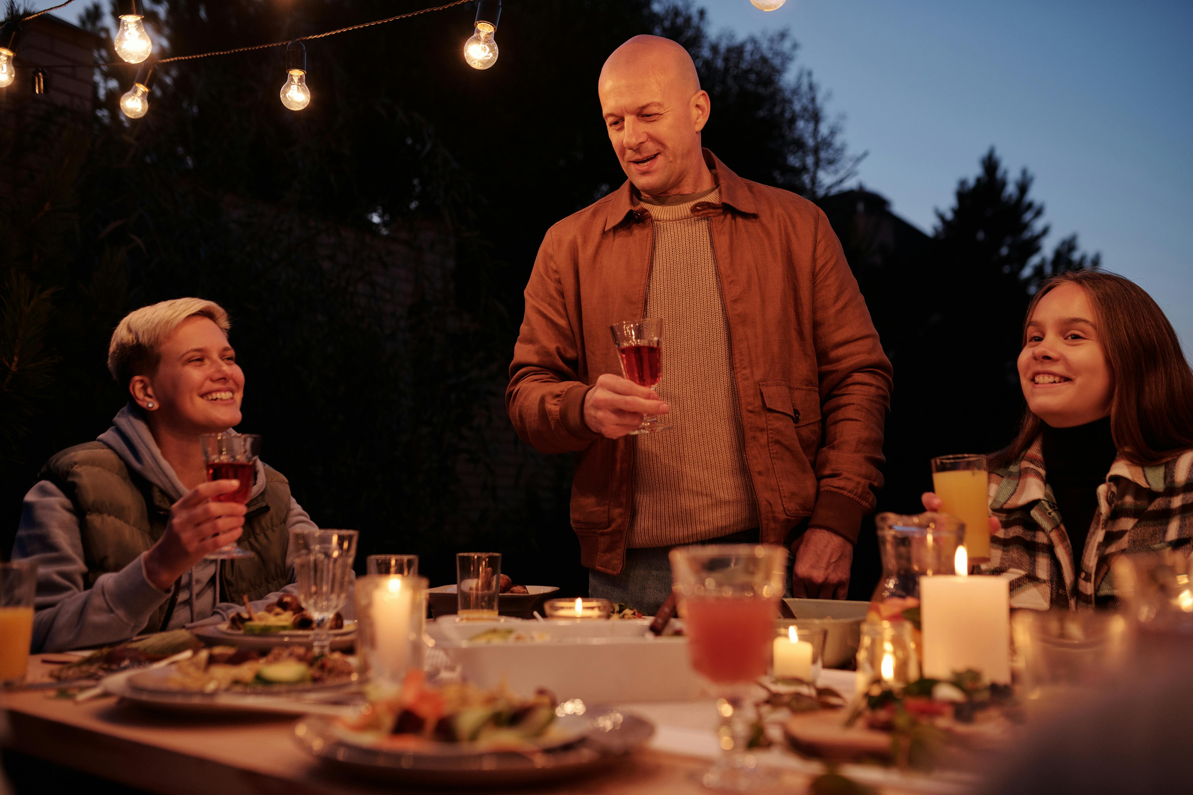 Hombre brindando durante una cena familiar | Fuente: Pexels