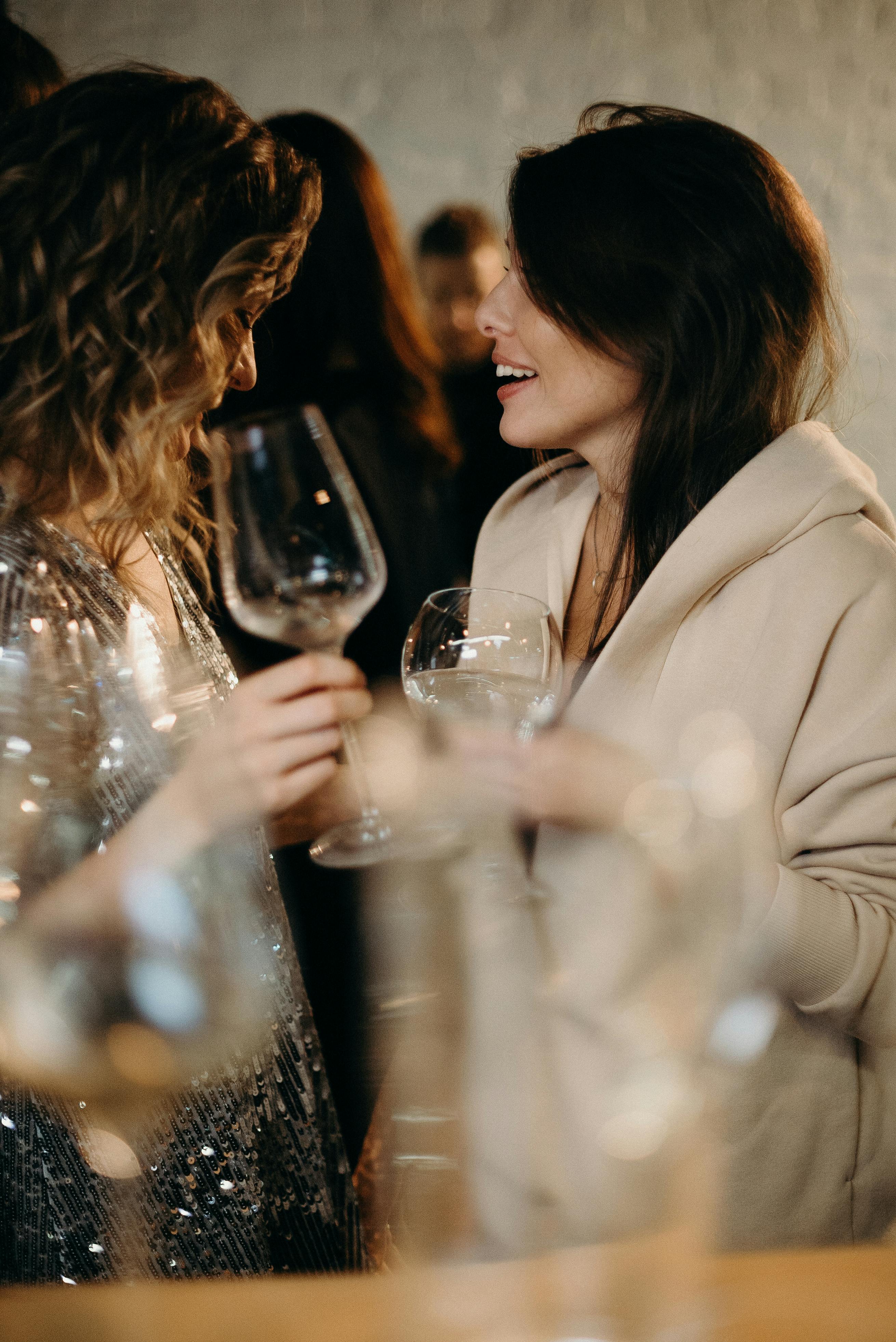 Mujeres sujetando copas de vino | Fuente: Pexels