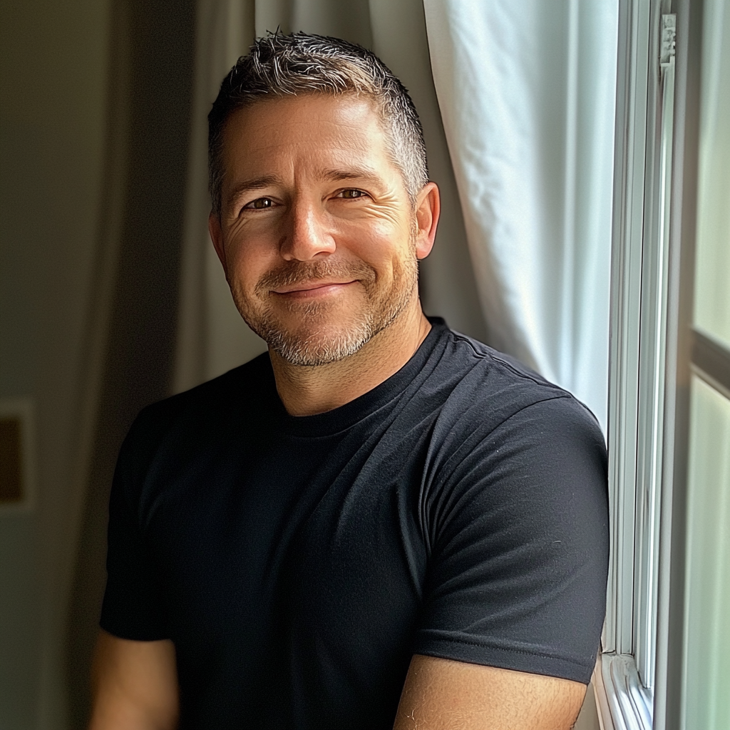 Un hombre sonriente junto a una ventana | Fuente: Midjourney