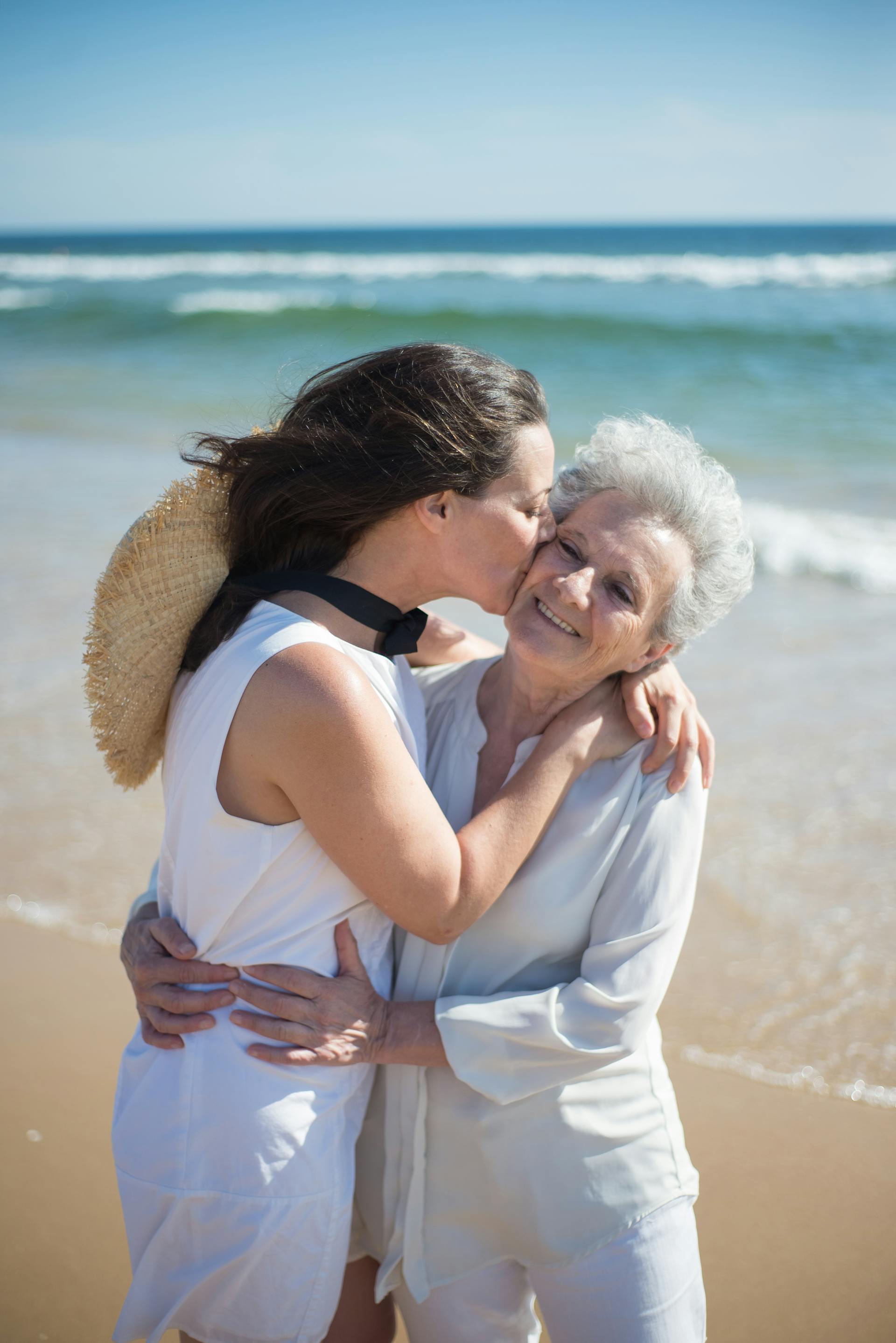 Una mujer besa a su madre en la playa | Fuente: Pexels