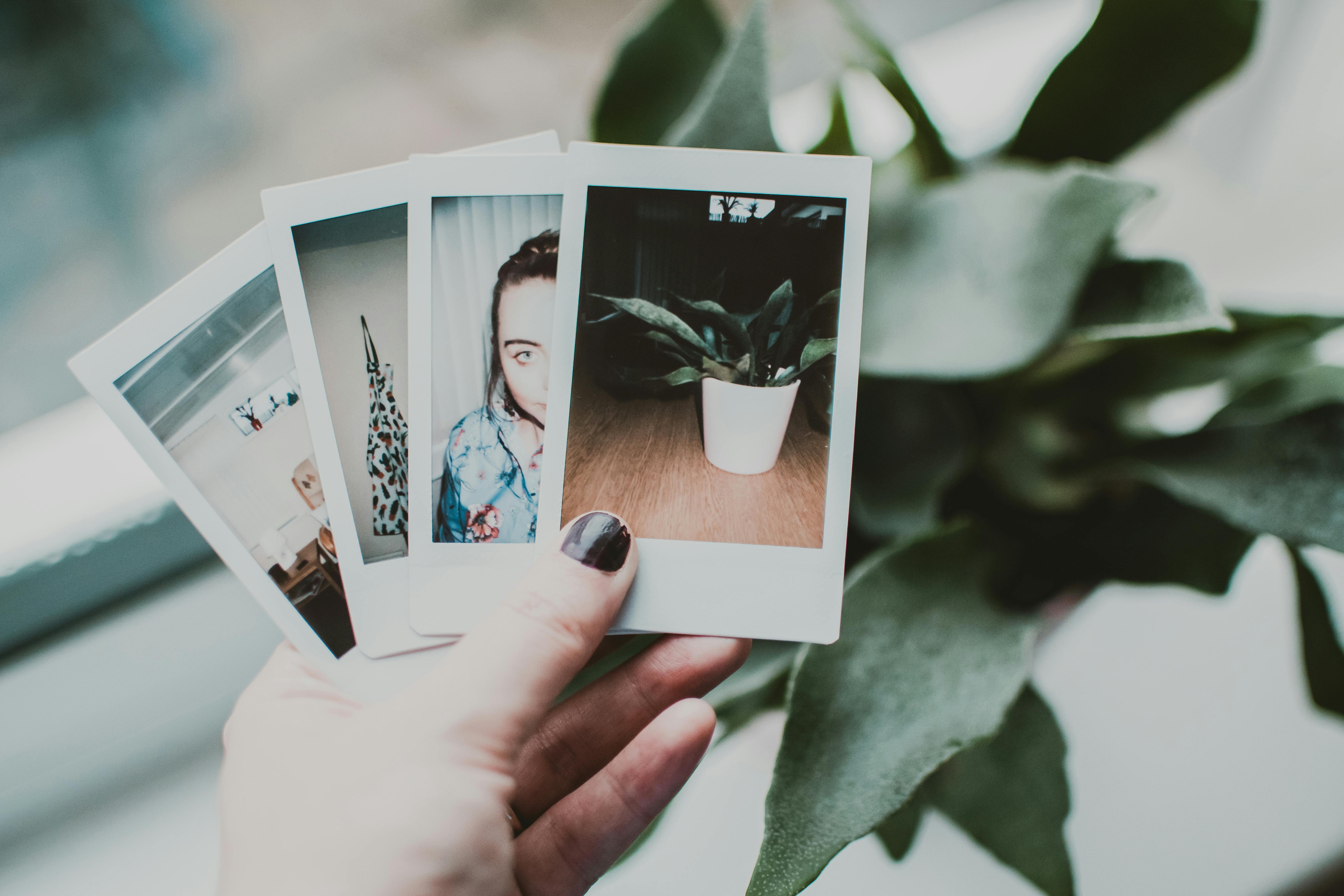 Una persona sosteniendo fotos polaroid | Fuente: Pexels