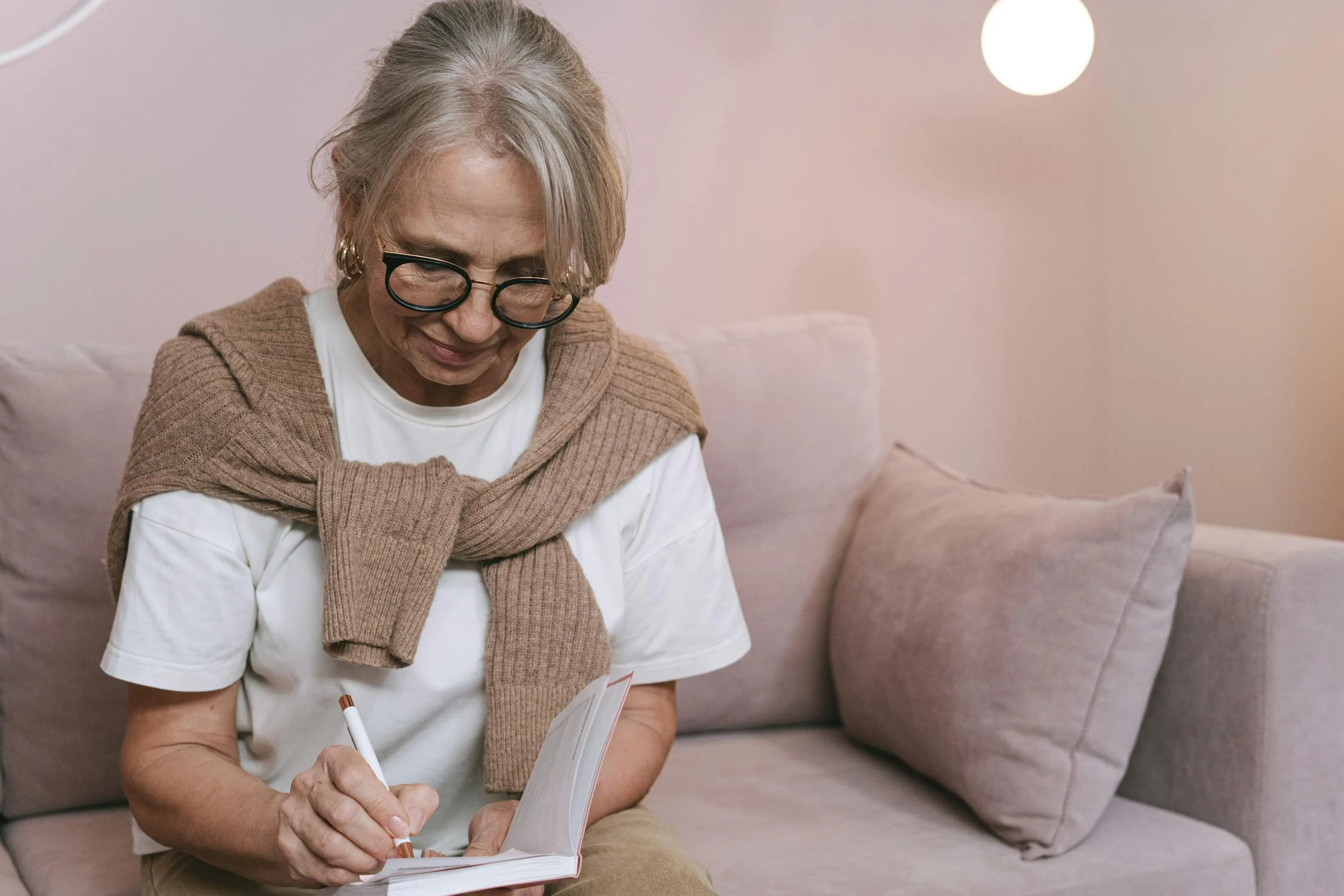 Una mujer escribiendo en su cuaderno | Fuente: Pexels