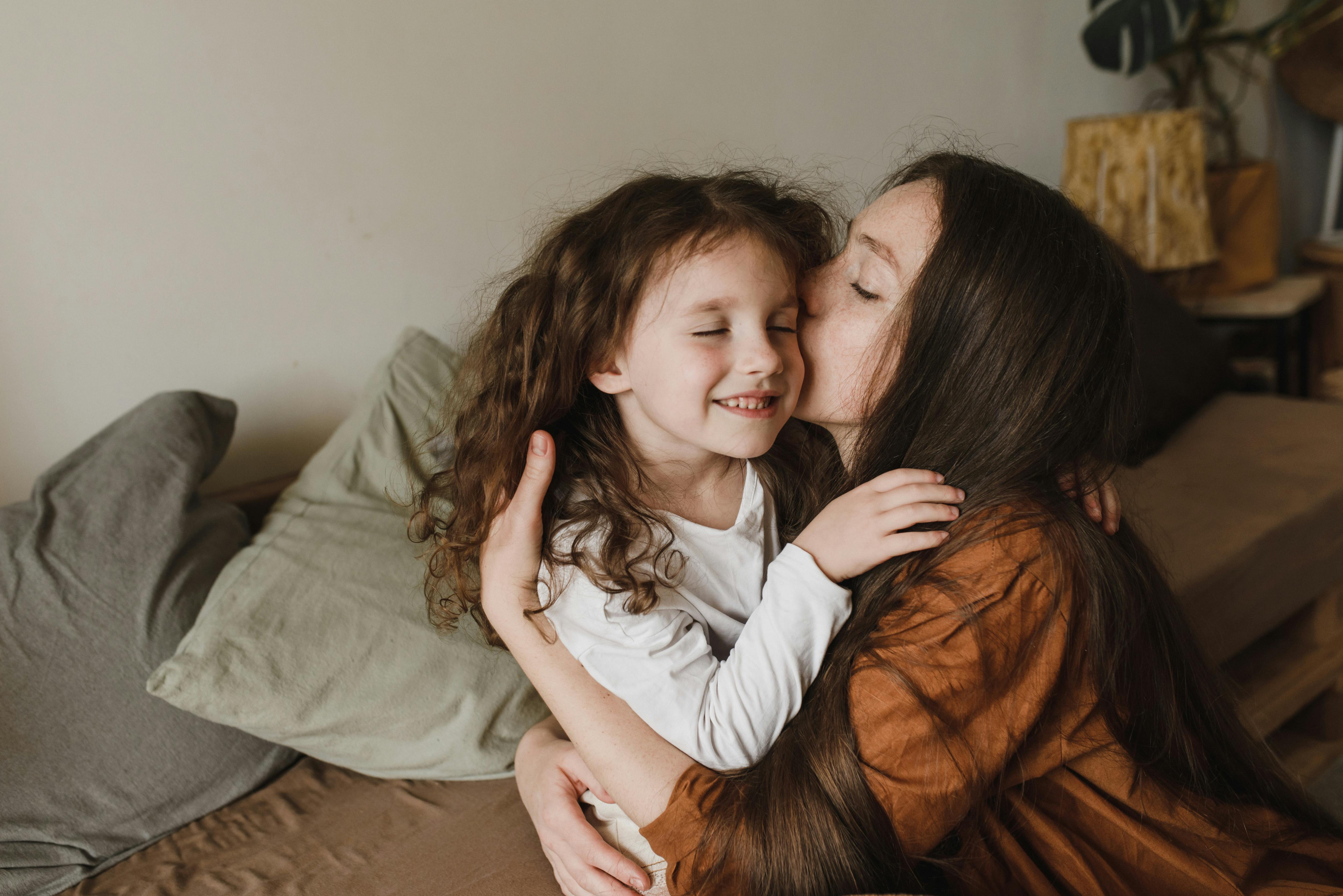 Una madre acurrucando a su hija | Fuente: Pexels
