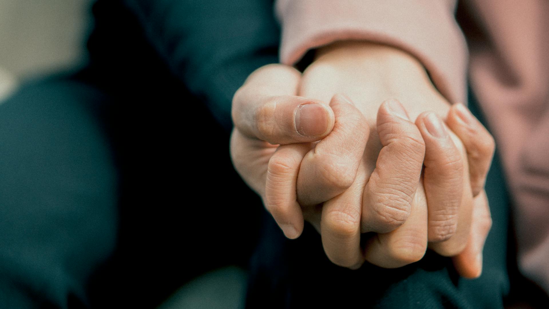 Primer plano de una pareja tomada de la mano | Fuente: Pexels