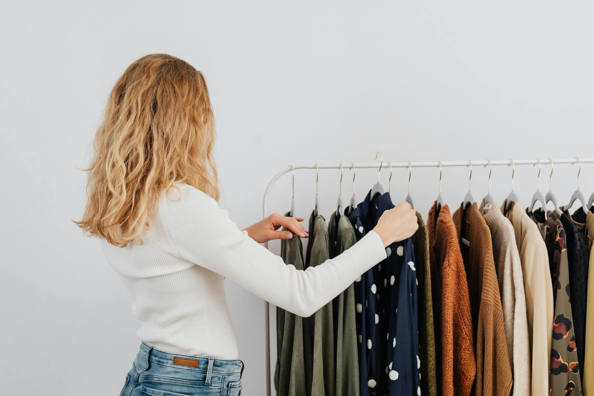 Una mujer cuelga ropa en un perchero | Fuente: Pexels