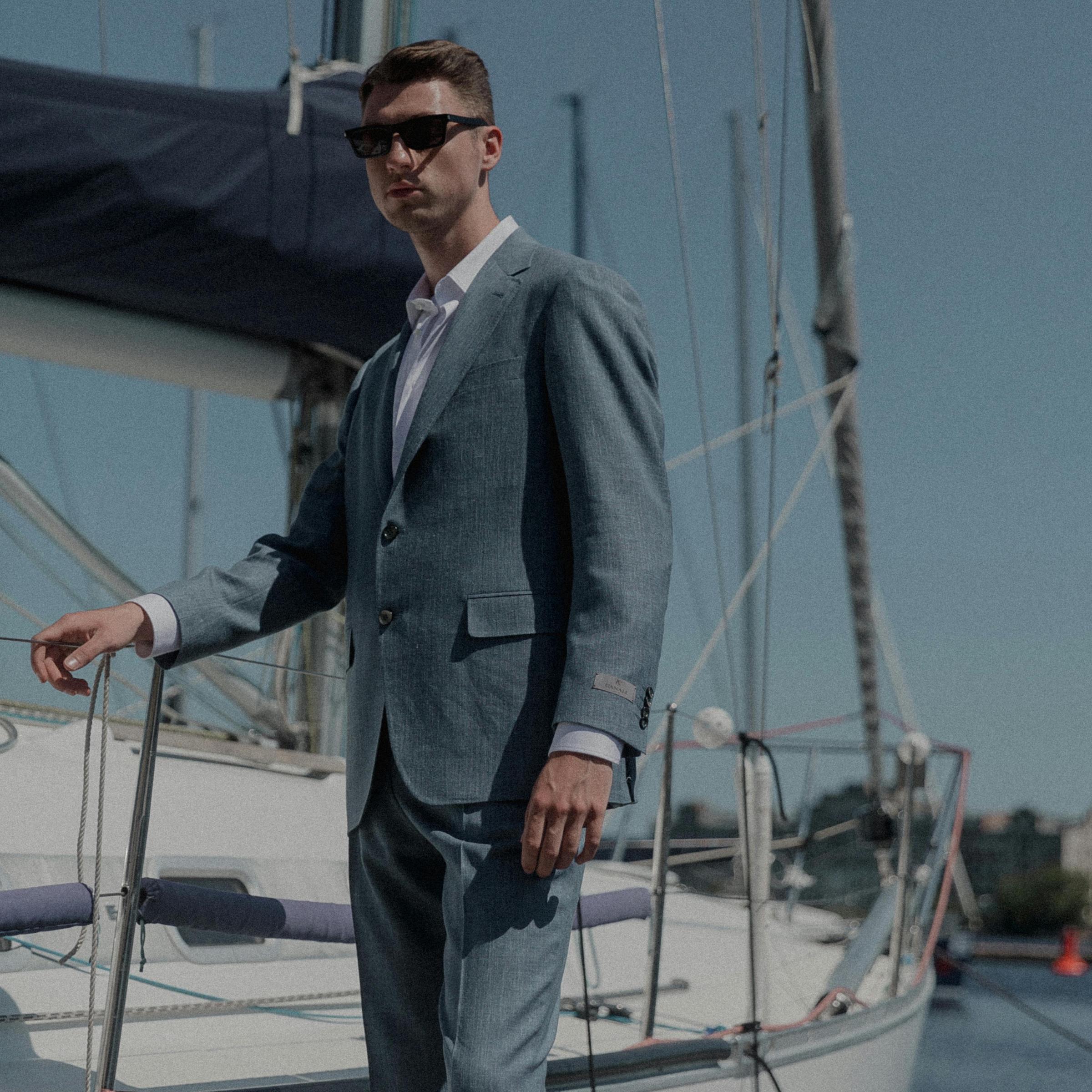 Un hombre elegantemente vestido en el muelle de un yate | Fuente: Pexels