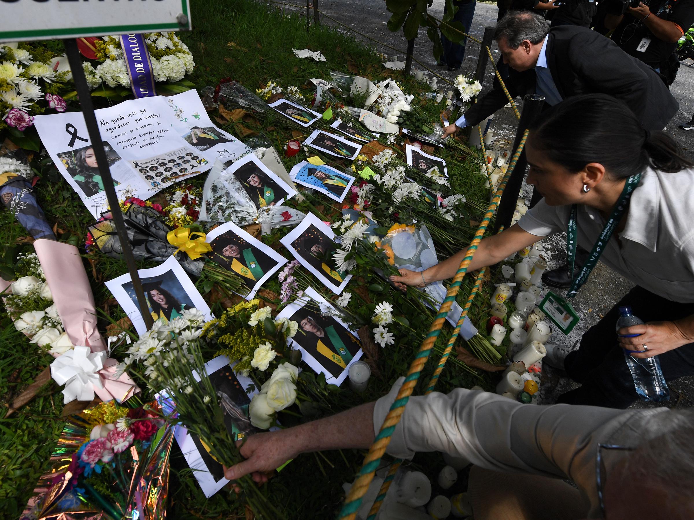 Personas colocan flores en homenaje a los estudiantes fallecidos en un accidente de autobús en el Liceo Antioqueño de Bello, Antioquia, Colombia, el 15 de diciembre de 2025. | Fuente: Getty Images