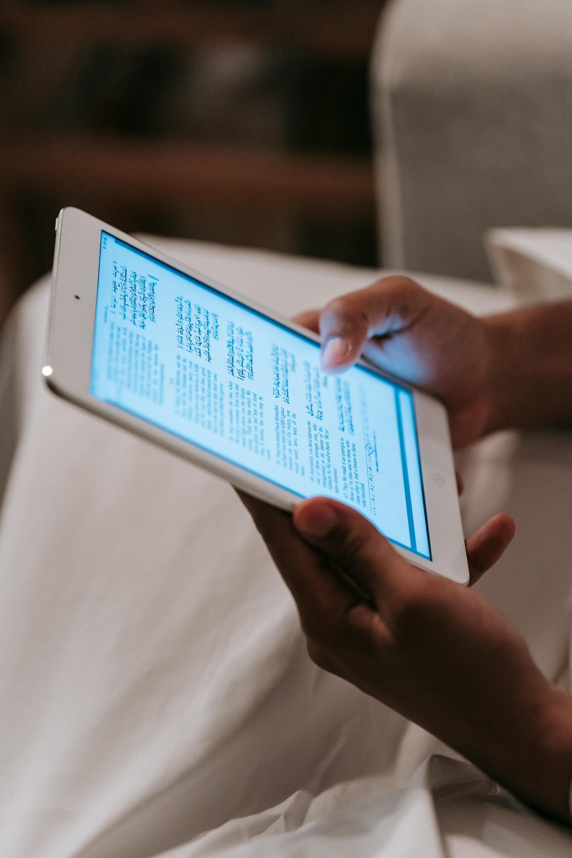 Una persona sostiene y mira una tableta con la pantalla encendida | Fuente: Pexels
