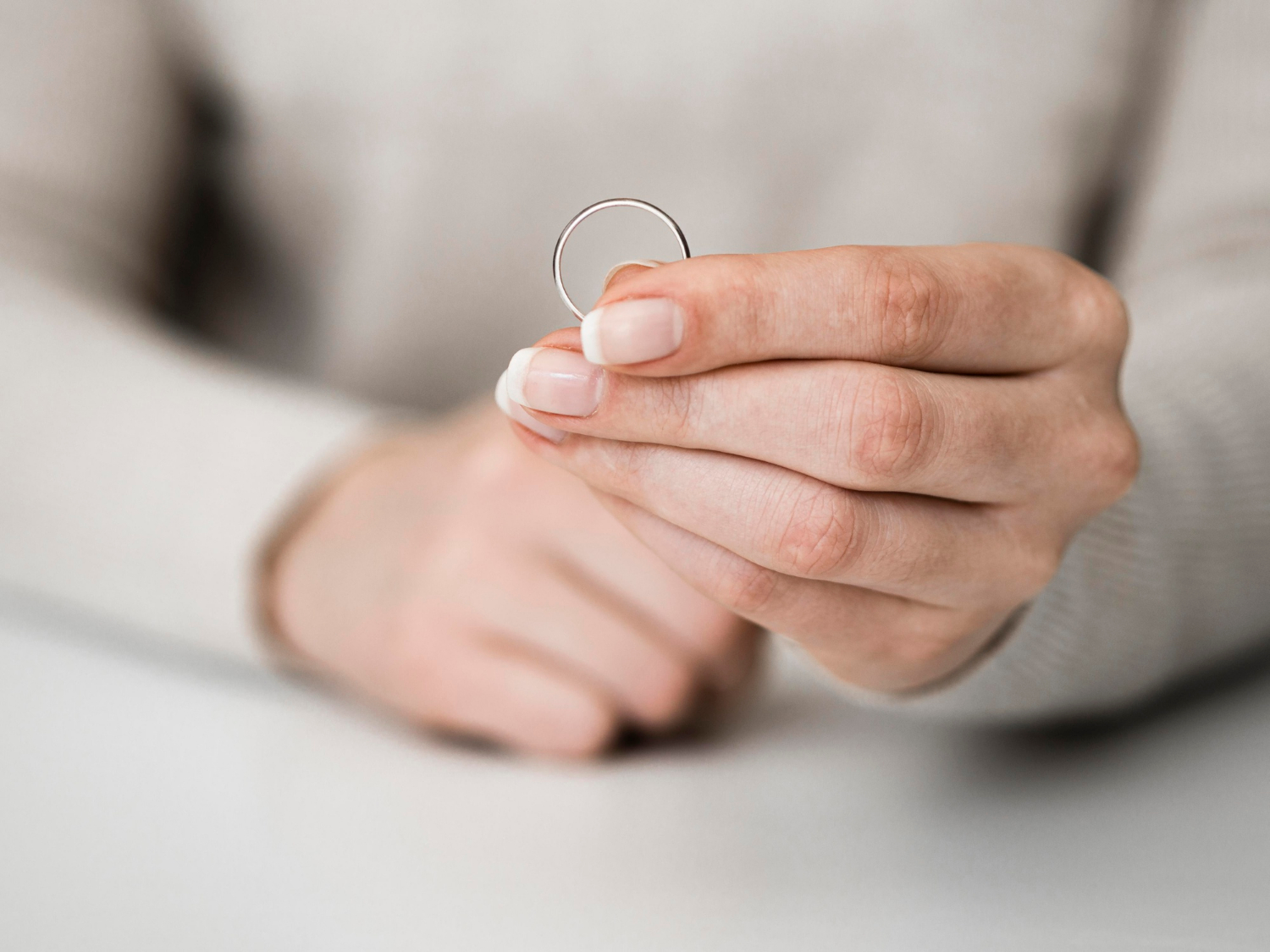 Una mujer sujetando un anillo de boda | Fuente: Freepik