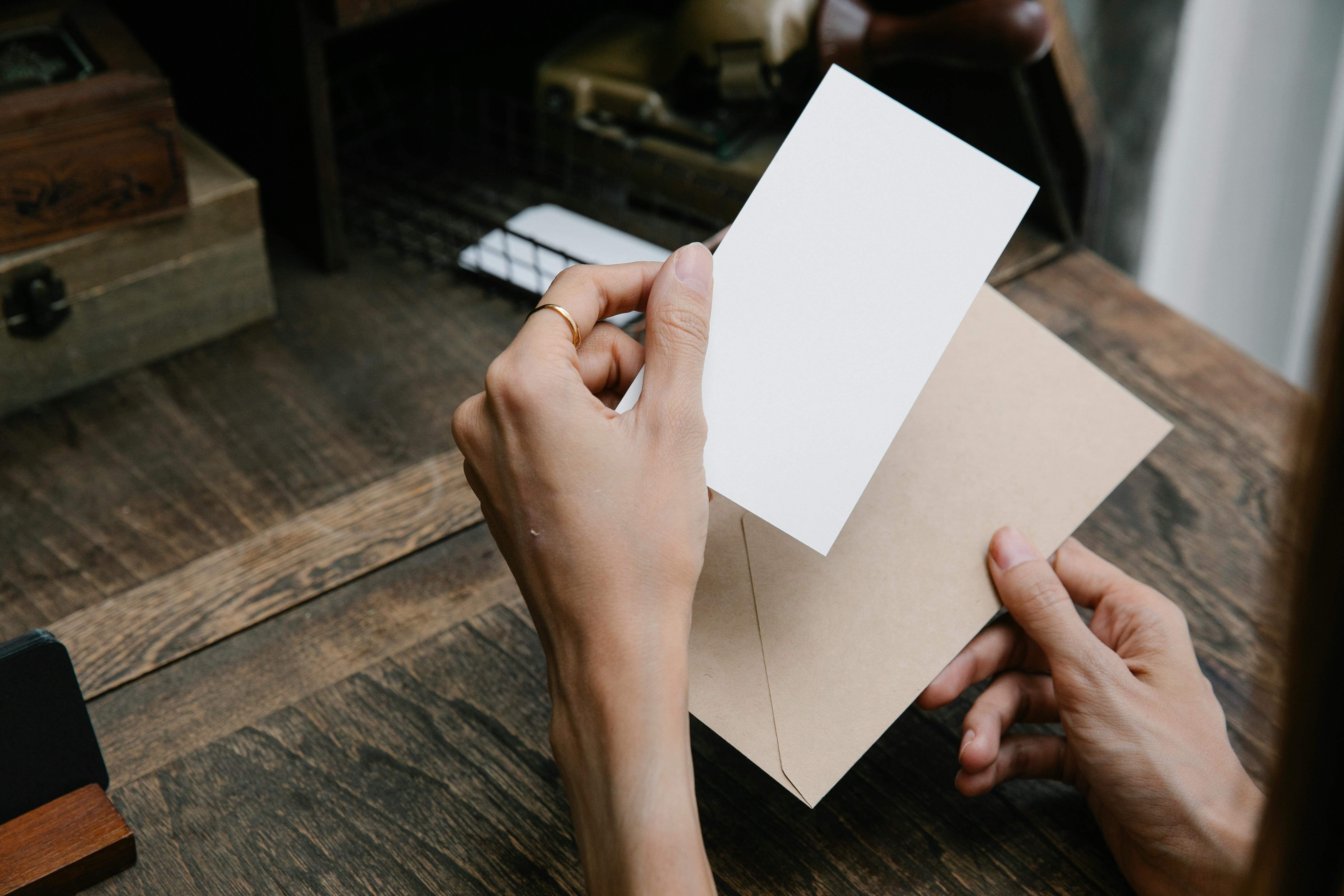 Una persona sostiene un papel y un sobre | Fuente: Pexels