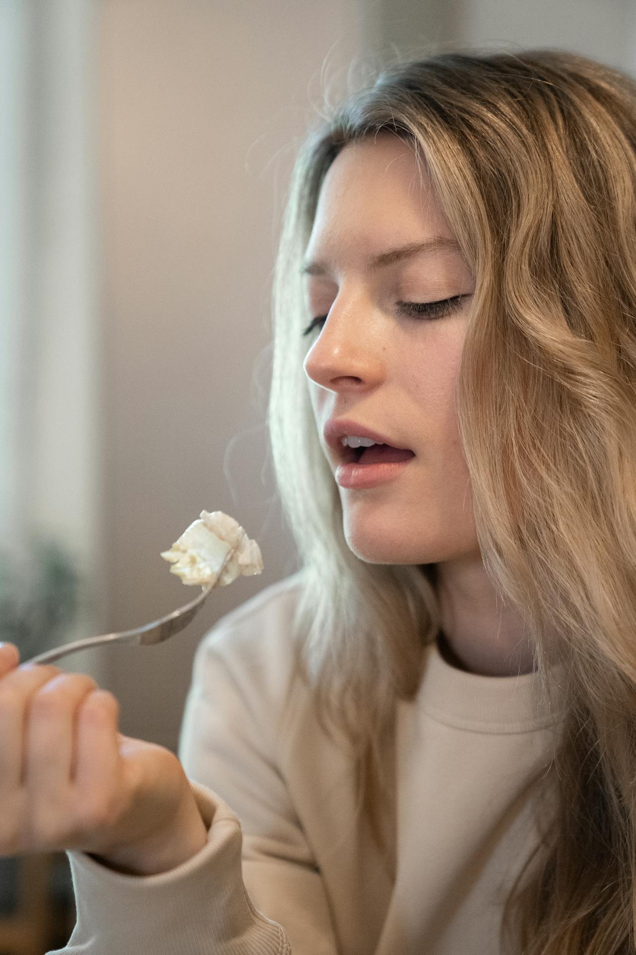 Una mujer comiendo usando un tenedor | Fuente: Pexels