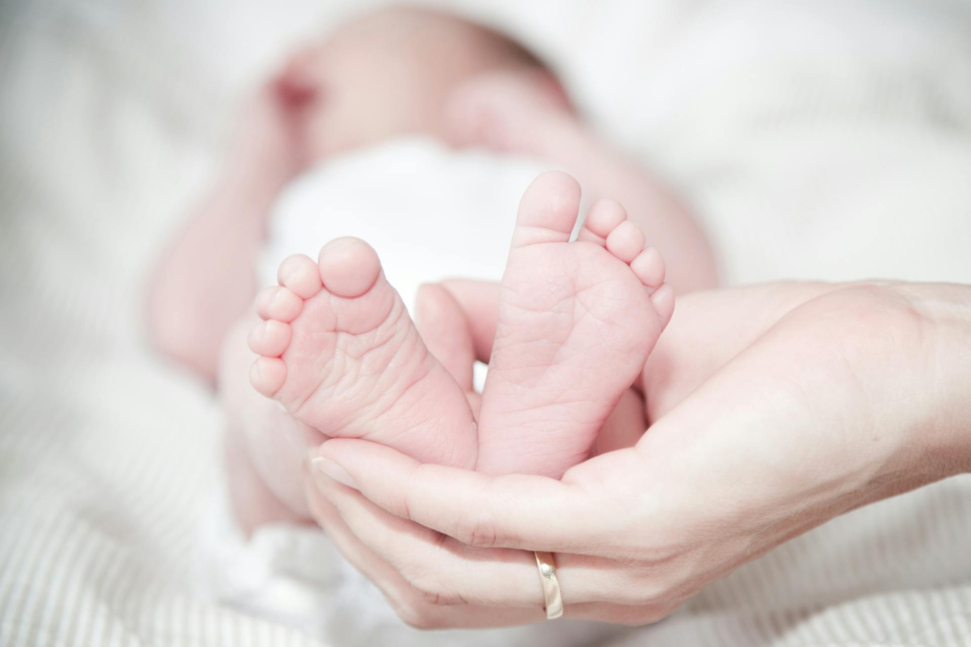 Una persona sujeta los pies de un bebé | Fuente: Pexels