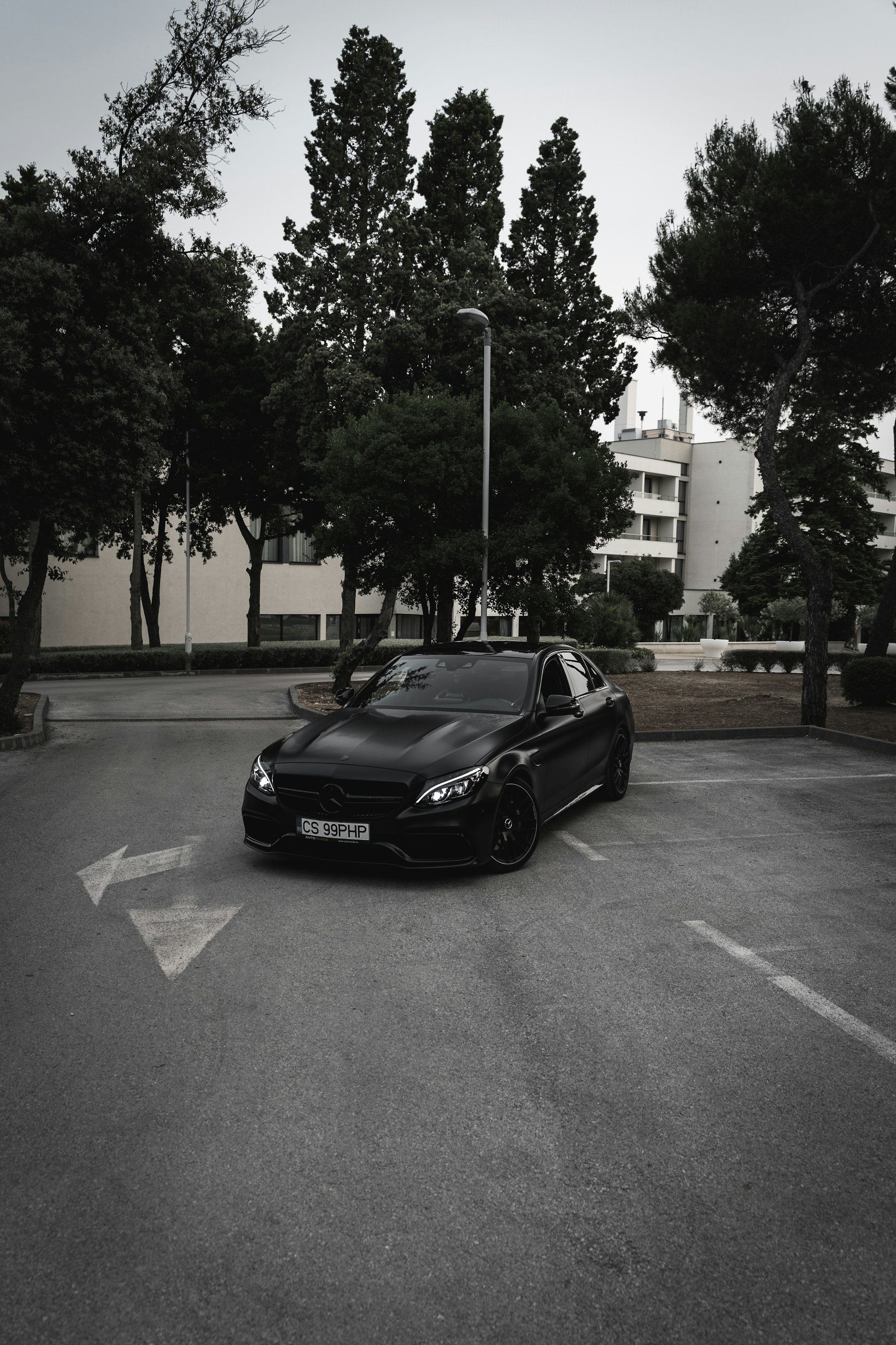 Un automóvil negro estacionado en el aparcamiento exterior de un edificio | Fuente: Unsplash