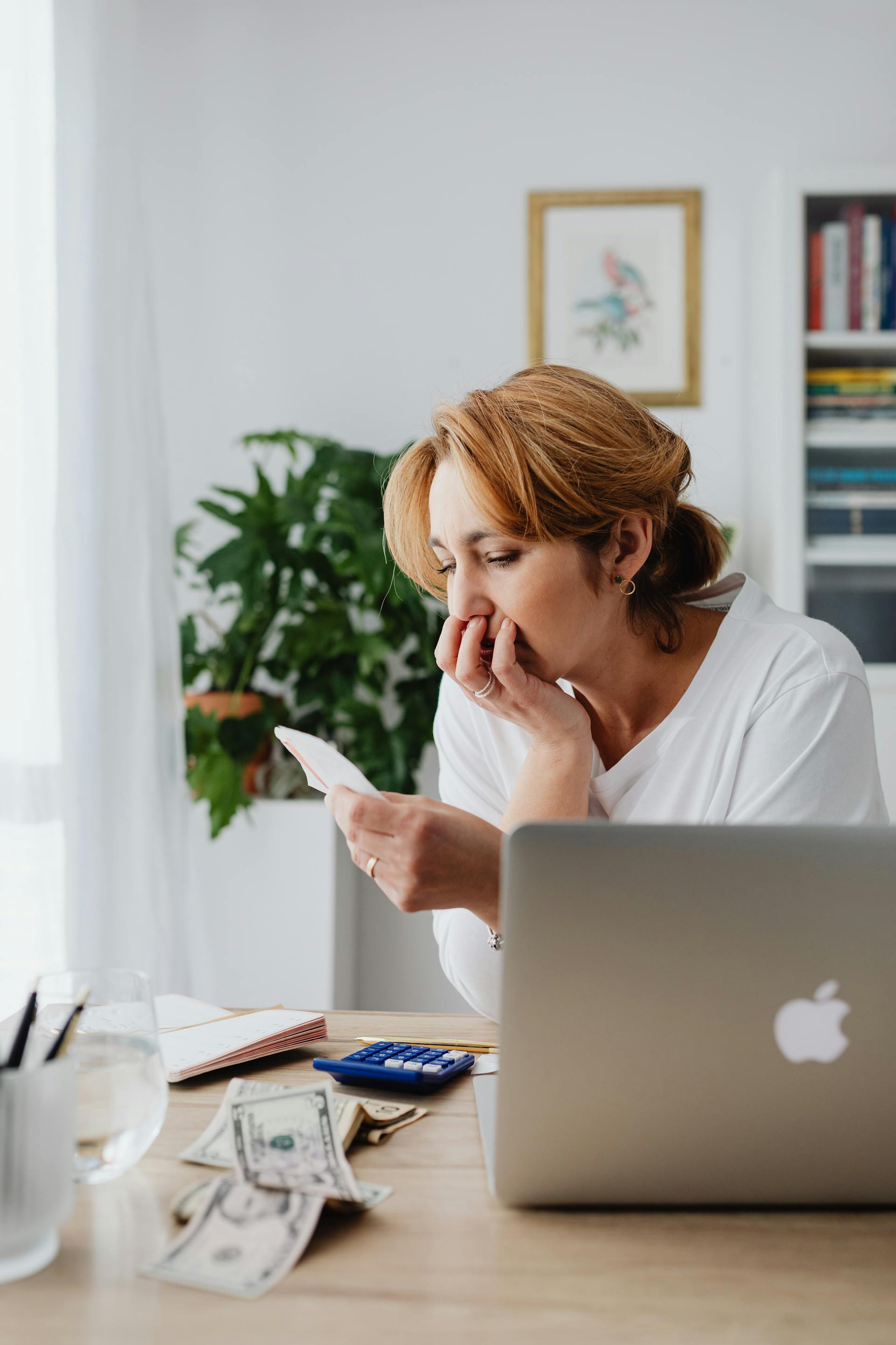 Una mujer pensativa sentada en un escritorio | Fuente: Pexels