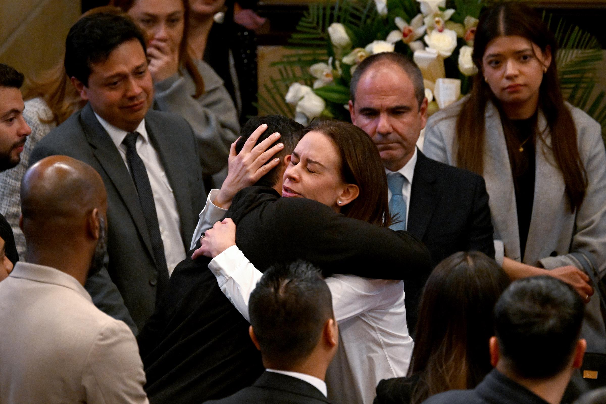María Claudia Tarazona (C-D), viuda del difunto candidato presidencial colombiano Miguel Uribe, abraza a una persona antes de la ceremonia fúnebre celebrada en el Congreso de Bogotá el 11 de agosto de 2025. | Fuente: Getty Images