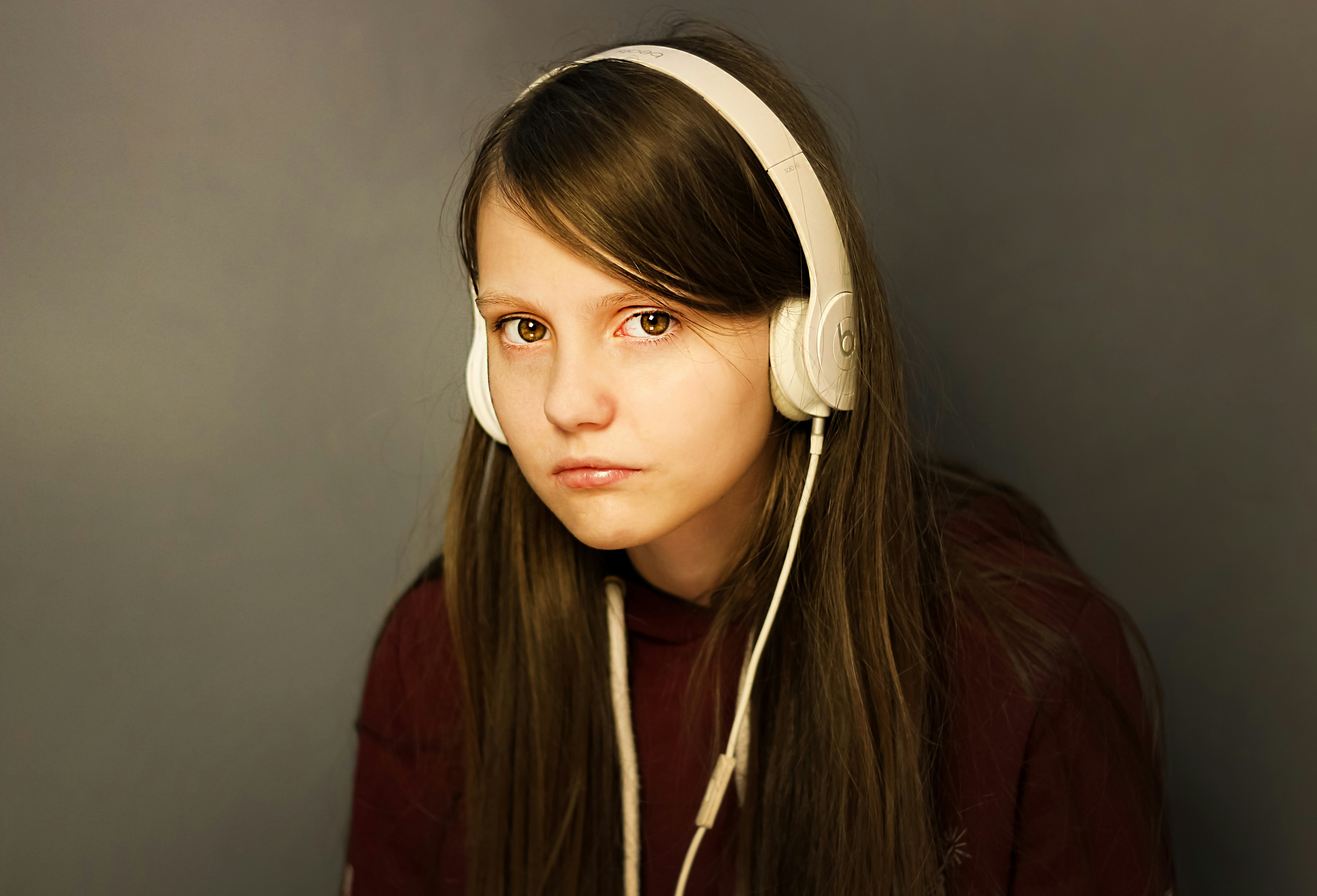 Una adolescente emocionada con auriculares | Fuente: Unsplash