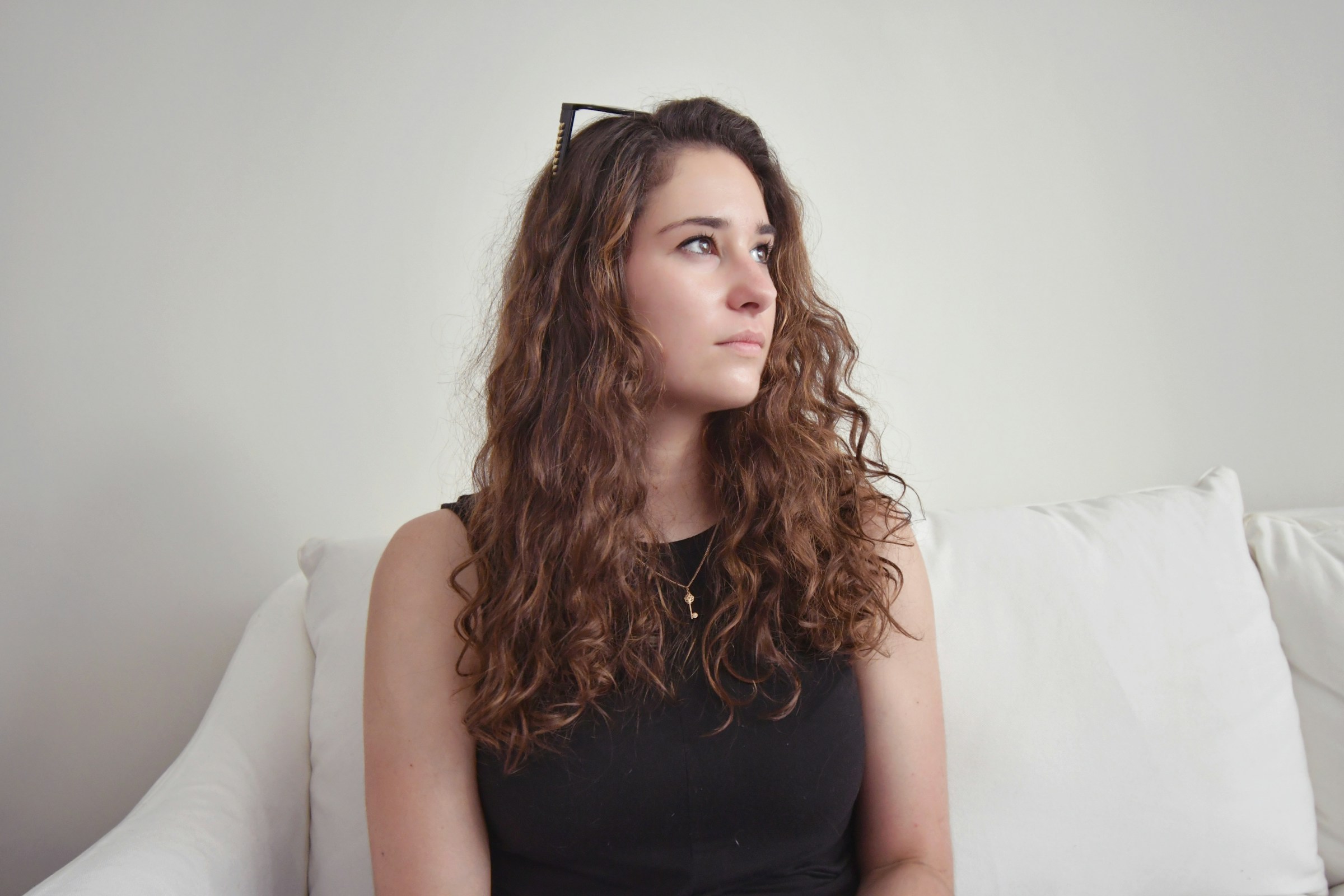 Una mujer sentada en un sofá y mirando de reojo | Fuente: Unsplash