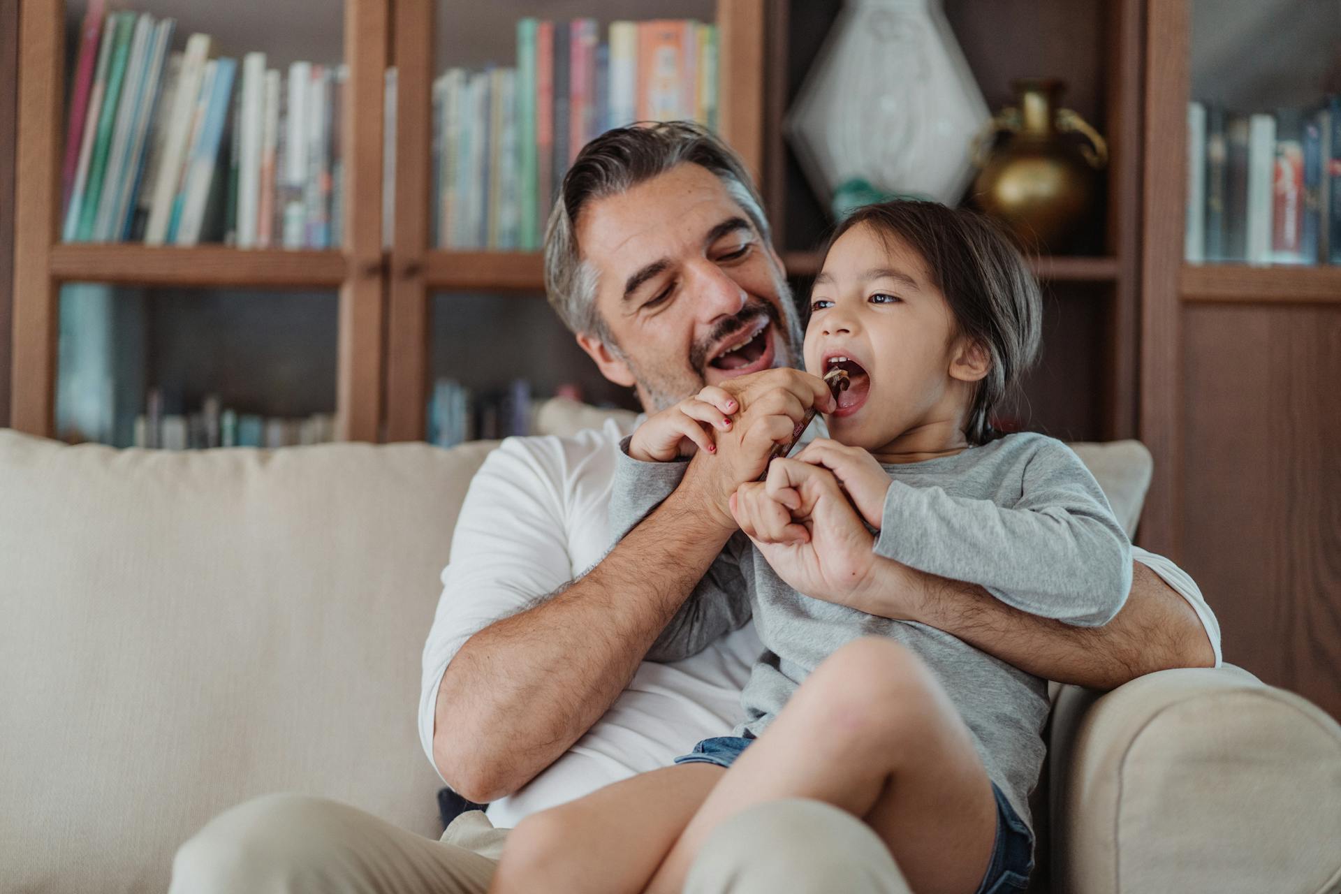 Un hombre compartiendo caramelos con una niña | Fuente: Pexels