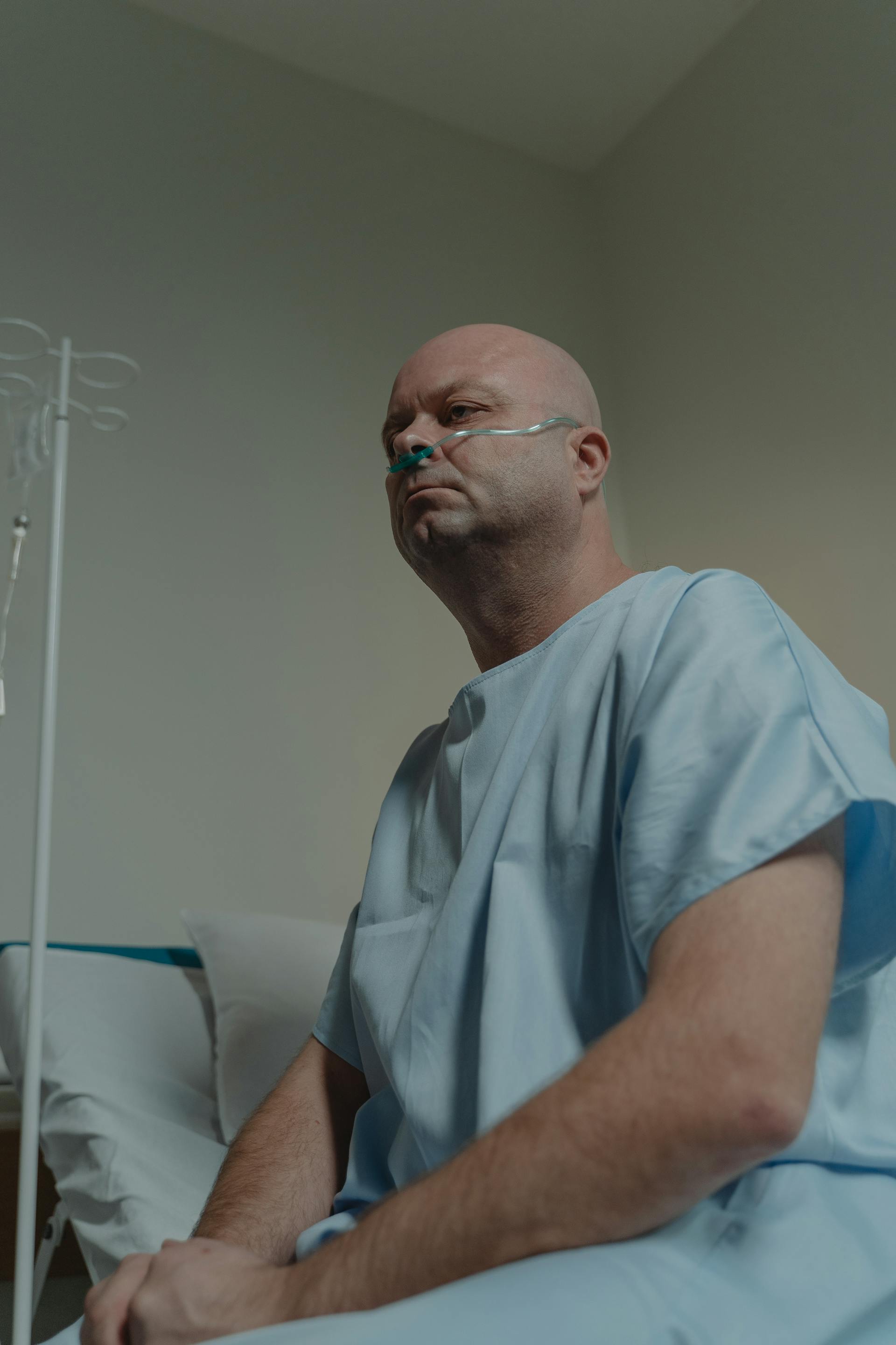 Un hombre enfermo sentado en una cama de hospital | Fuente: Pexels