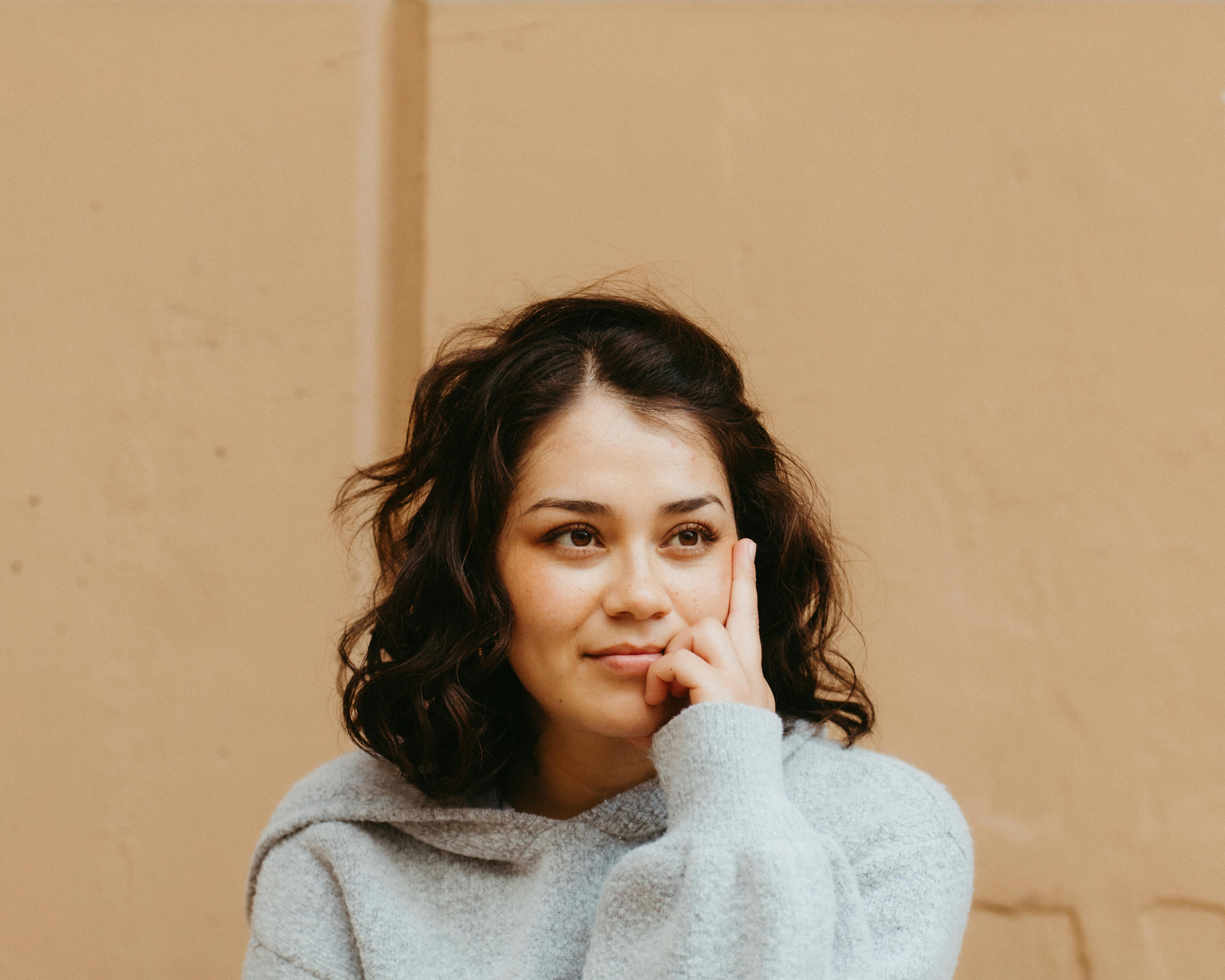 Una mujer sonriendo mientras piensa | Fuente: Pexels