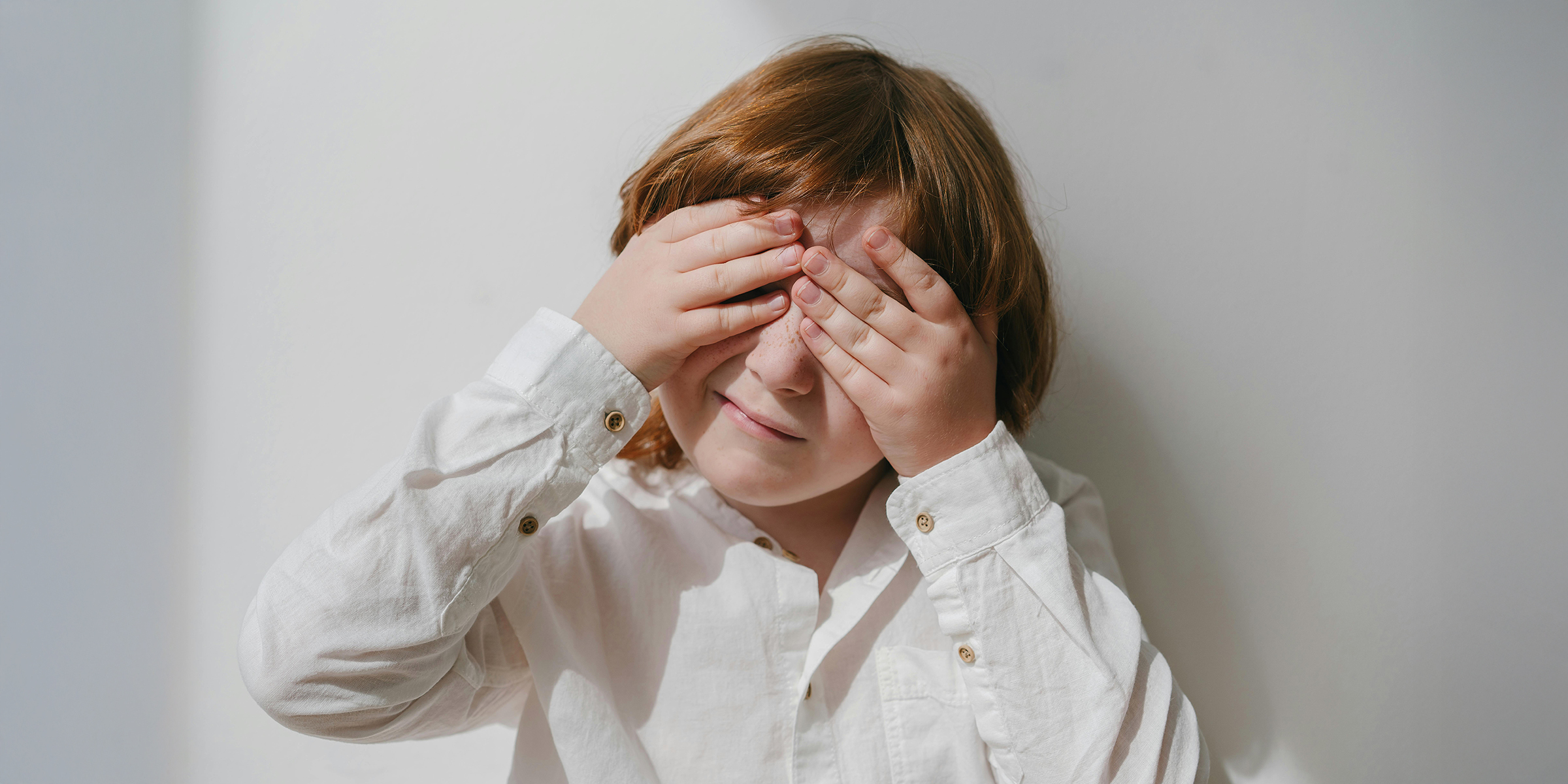 Niño ocultando su cara con las manos | Fuente: Pexels