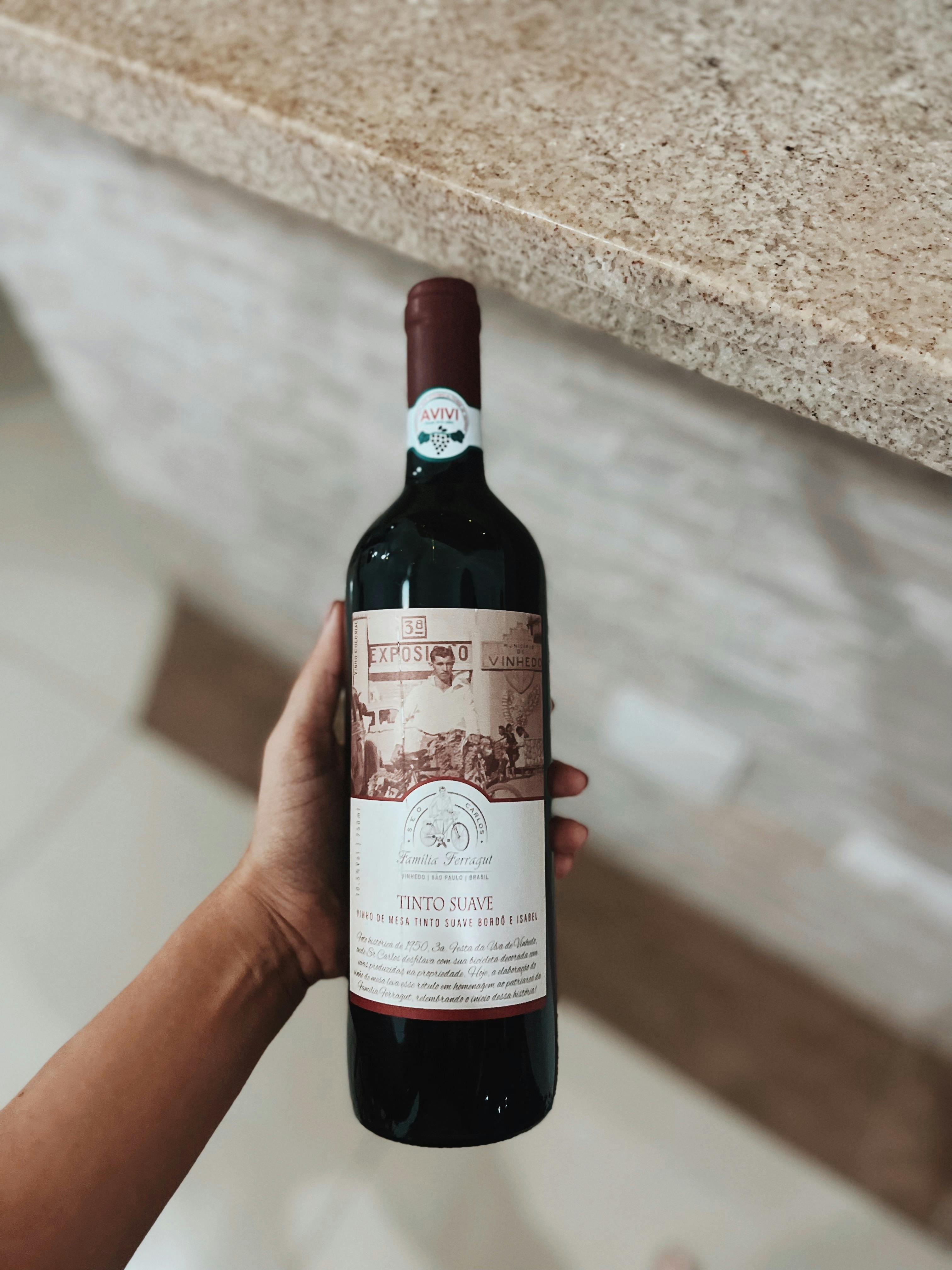 Una persona con una botella de vino en la mano | Fuente: Pexels