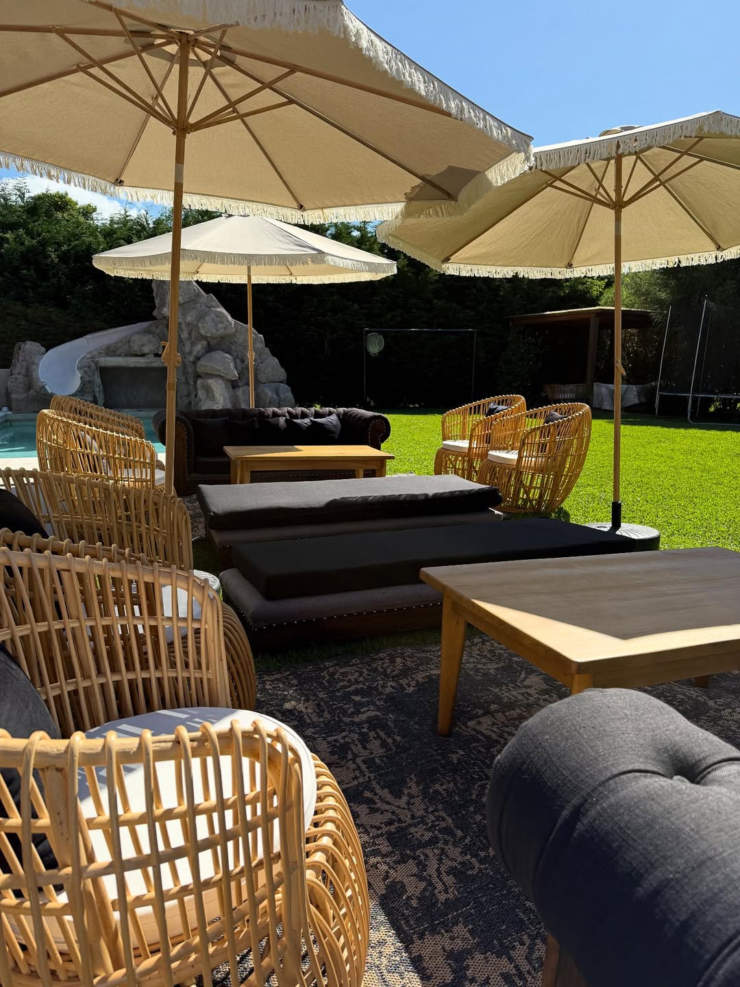Jardín en la casa de Cinthia Fernández decorado con sillones de mimbre, mesas bajas, alfombras persas y sombrillas, para la celebración de su cumpleaños | Fuente: Instagram/cinthia_fernandez_